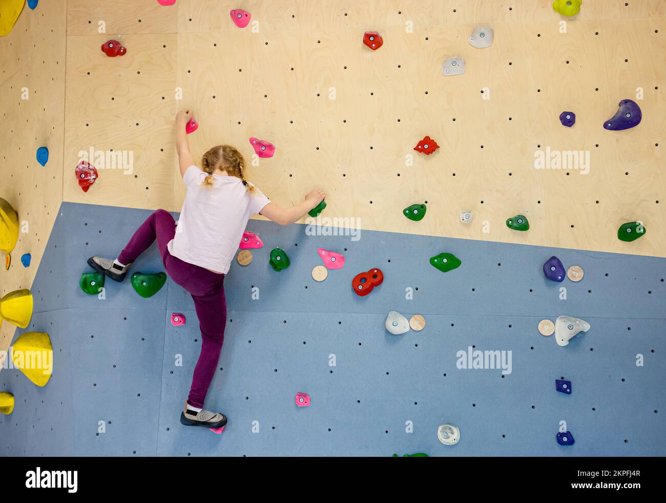 Sporty strong young woman in black outfit exercising in boulder climbing  hall reaching new results, enjoying new challenges Stock Photo - Alamy