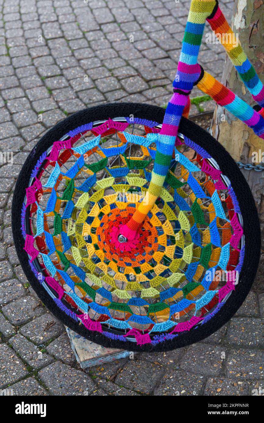 Colourful yarn bombing bike, yarn bomb crochet crocheted wheel of bike in Weymouth, Dorset UK in October Stock Photo
