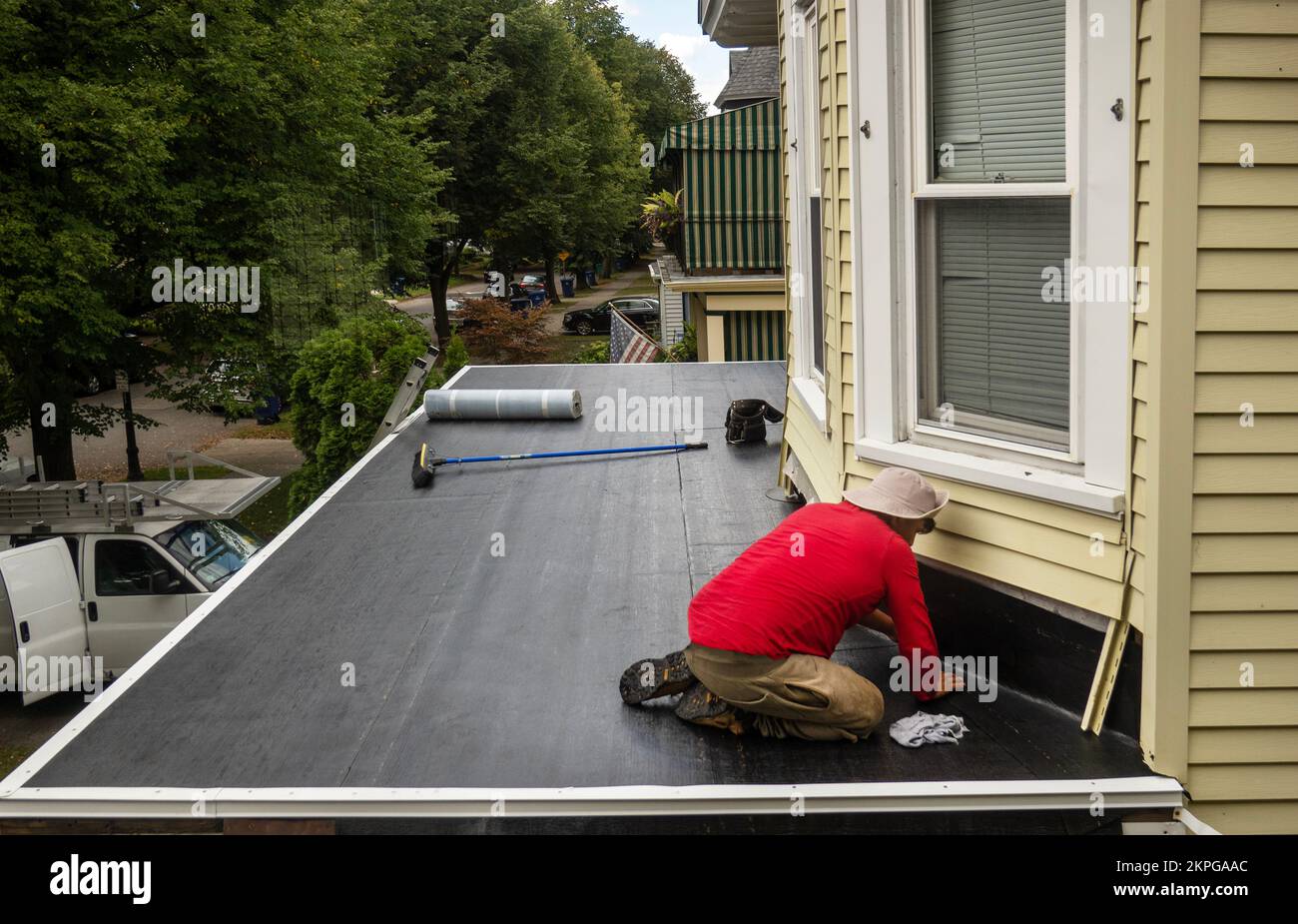 worker installing a roof on a house in Buffalo NY Stock Photo
