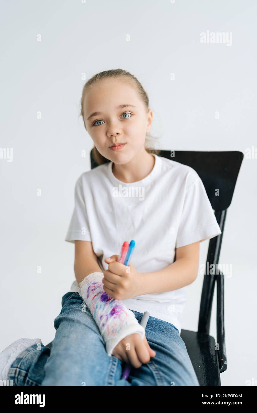 Vertical portrait of positive little girl drawing cute image with