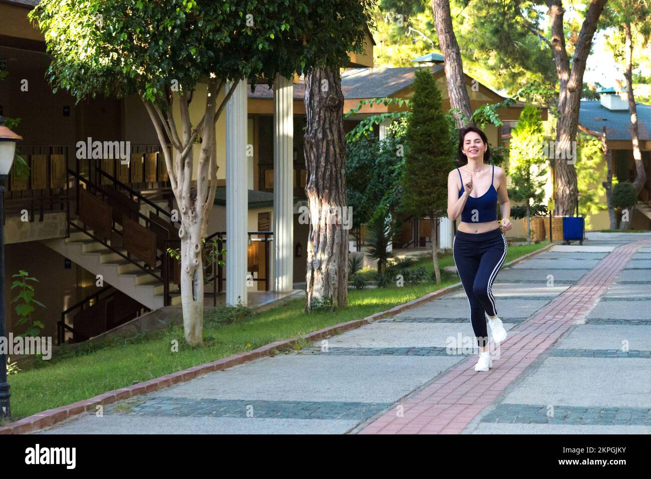 Morning jog near her country house, a woman goes in sports Stock Photo