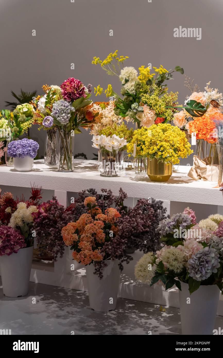 Beautiful showcase of flower shop with large assortment of artificial flowers. Stock Photo