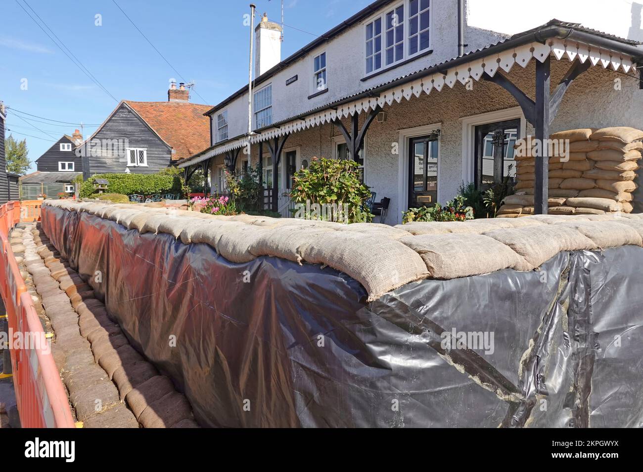 Close up of stacked filled sand bags placed around seafront cottage with sea frontage flooding at high tides on West Mersea island Essex England UK Stock Photo