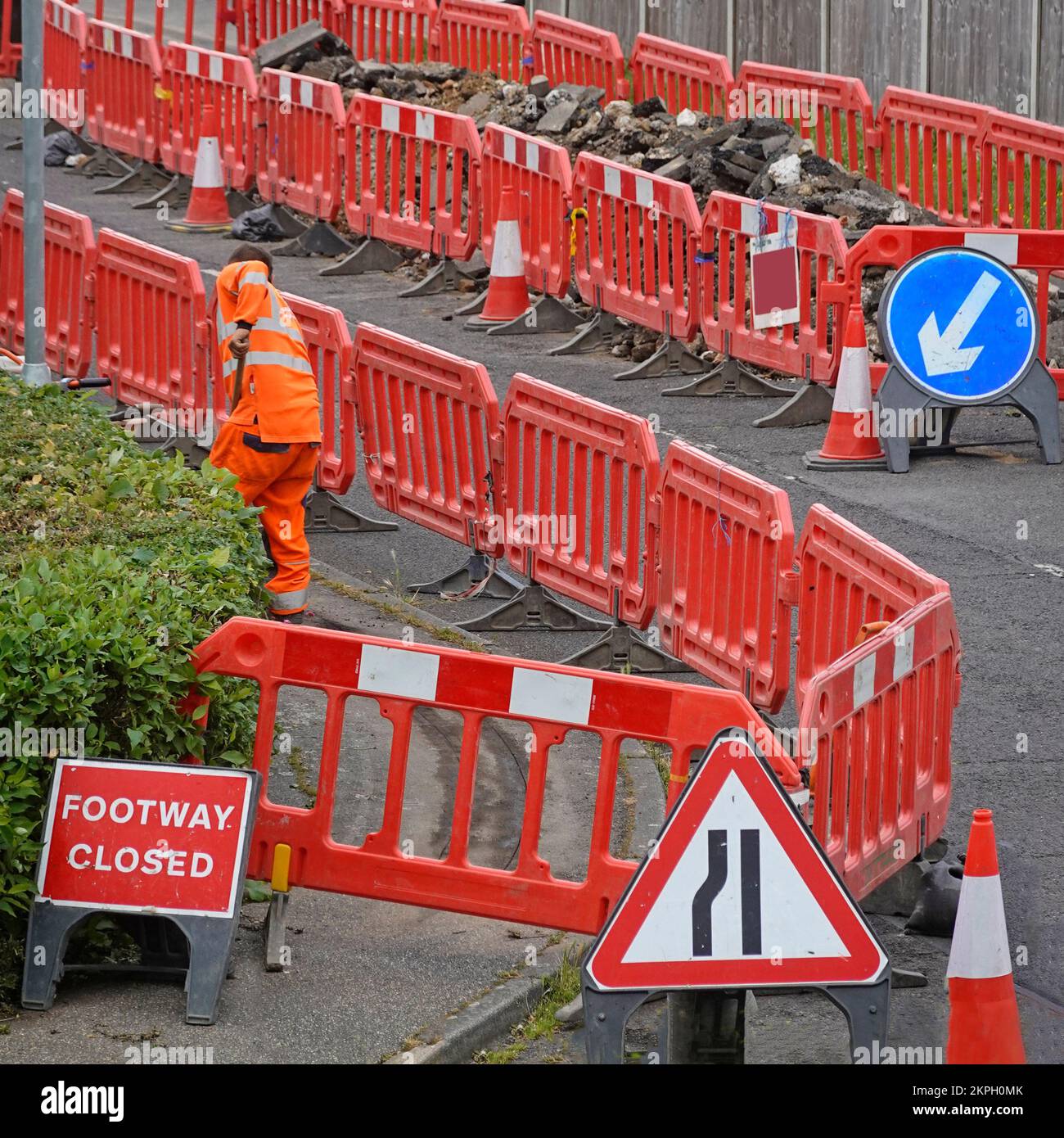 Footway closed sign for fibre optic broadband trenches & half village residential street taken over as dump compound for excavated material England UK Stock Photo