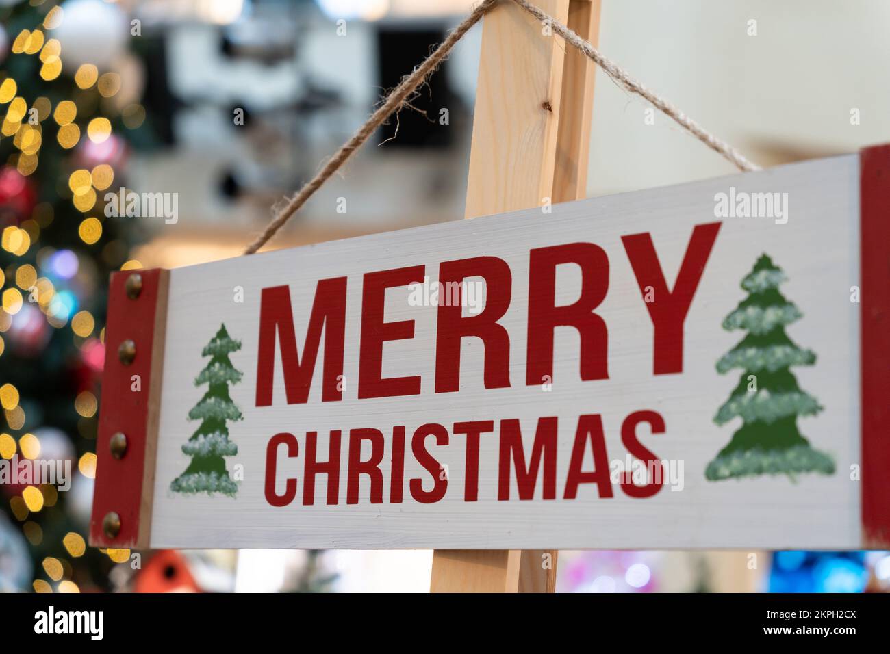 Wood Merry Christmas sign hanging on the timber column. Stock Photo
