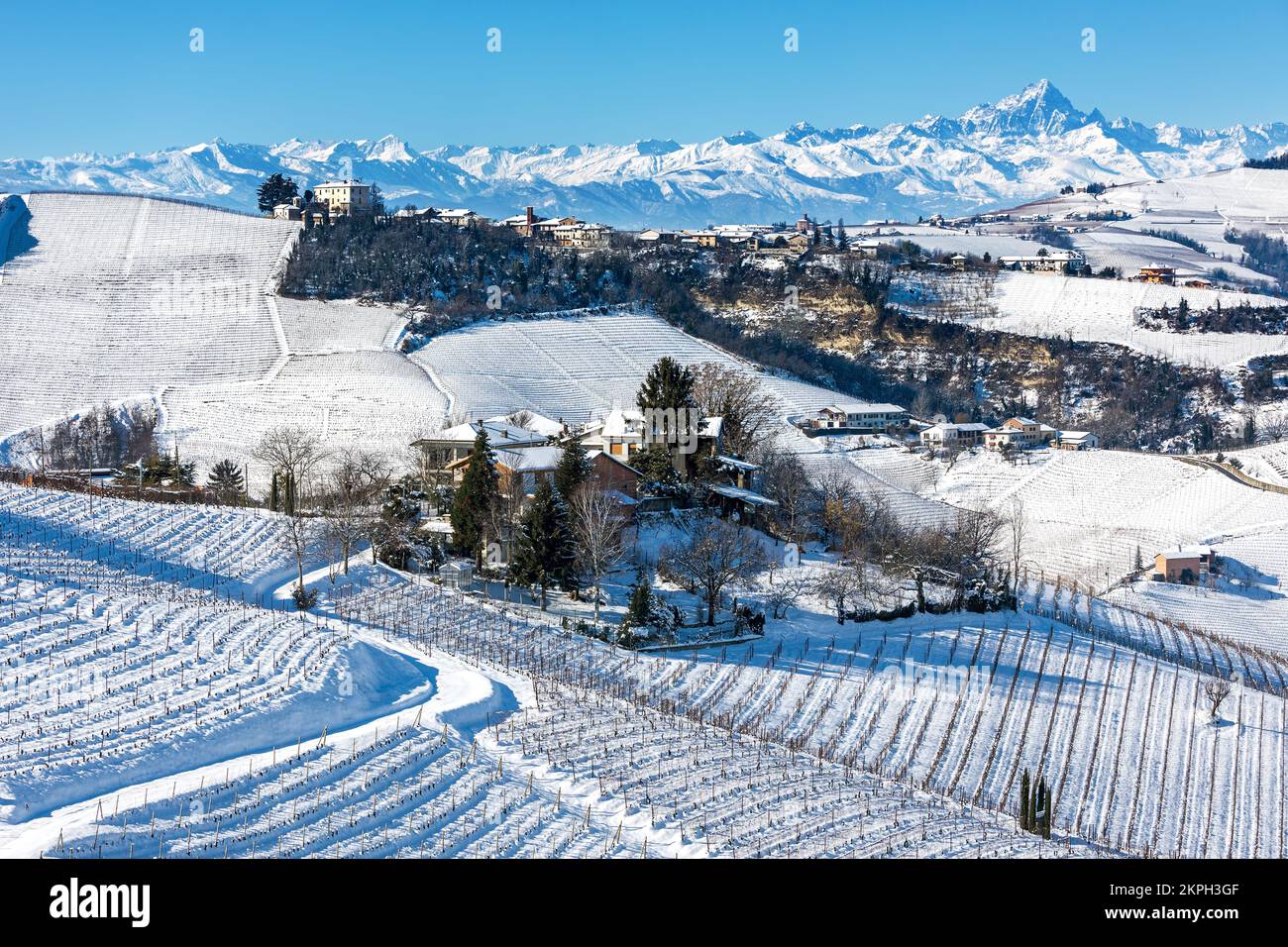 Houses on the hills among vineyards covered in snow in Piedmont, Northern Italy. Stock Photo
