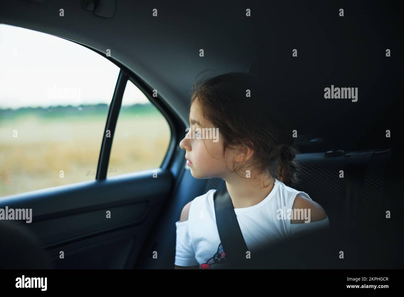 Little Girl in auto baby seat in car looking at window Stock Photo