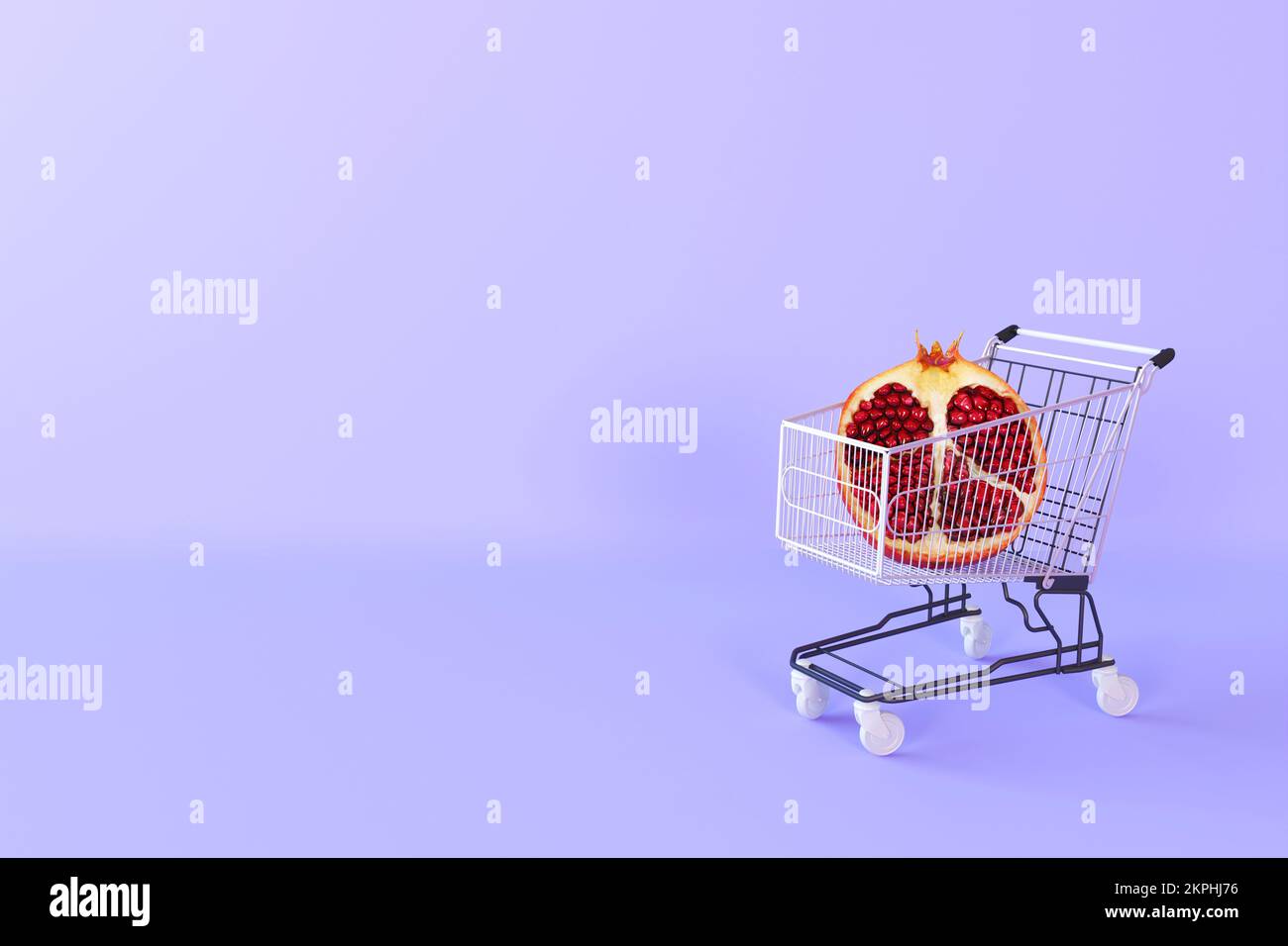 Pomegranate with seeds in tiny grocery basket. Healthy organic food. Creative concept for grocery store, food shop, supermarket. Banner promotion Stock Photo