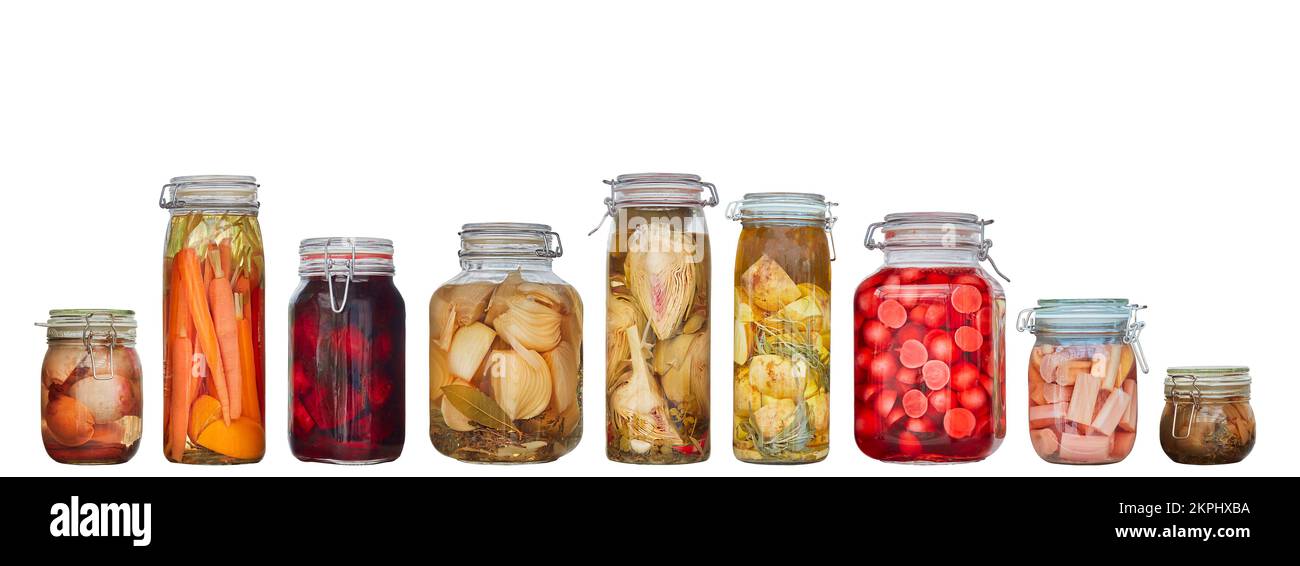 Row of nine glass canning jars with preserved vegetables isolated on a white background Stock Photo