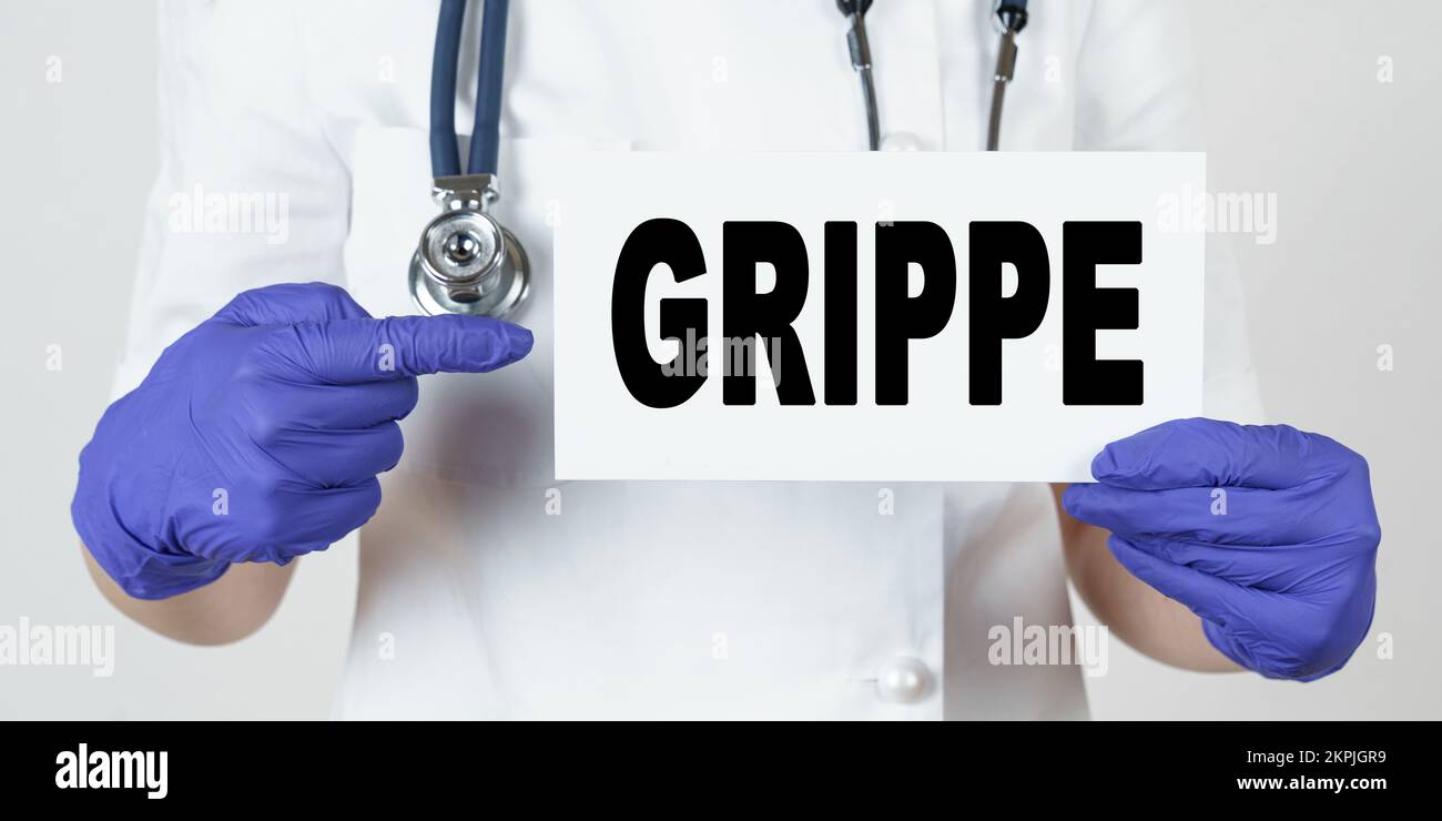 Medicine and health concept. The doctor points his finger at a sign that says - GRIPPE Stock Photo