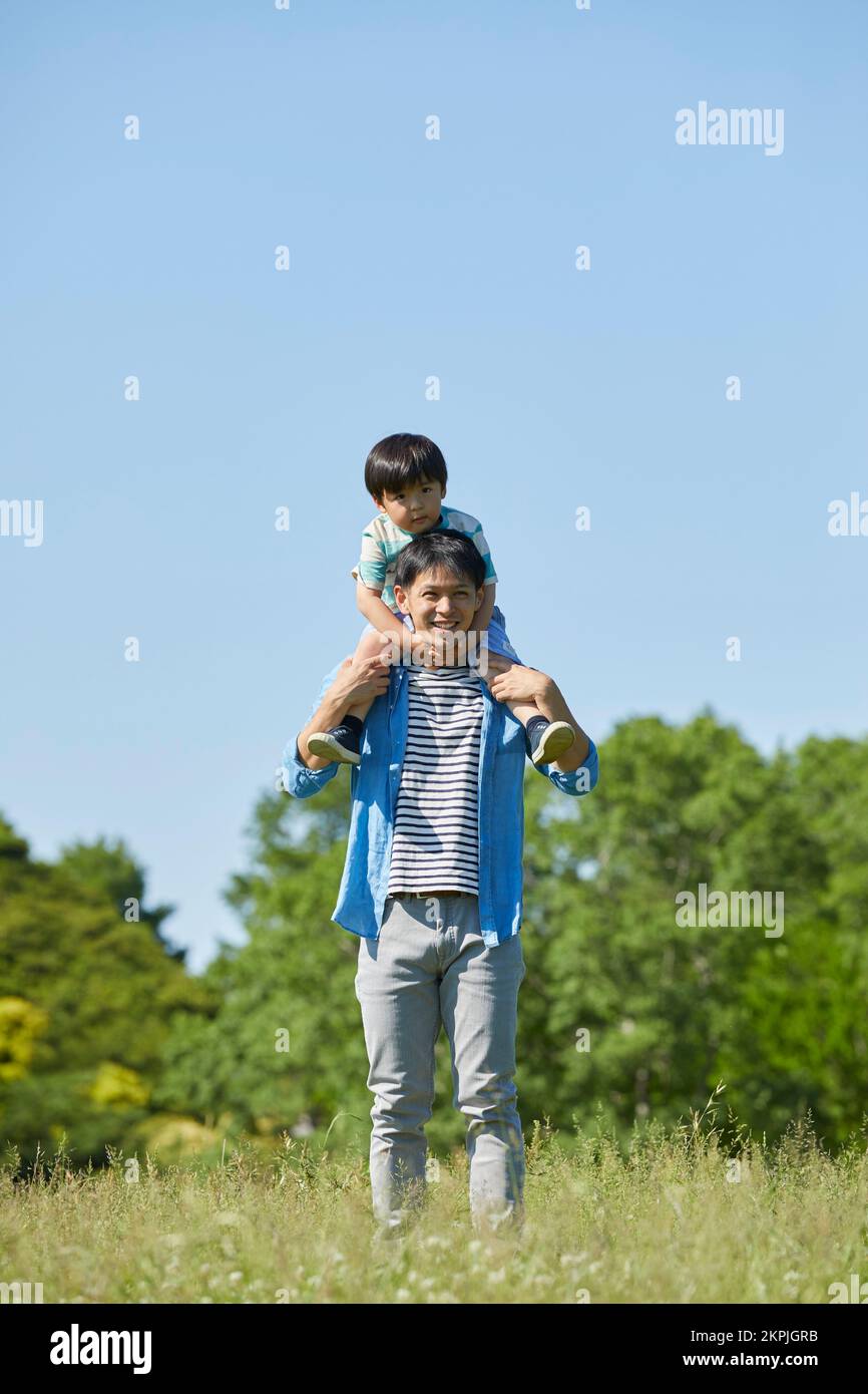 Japanese father carrying his child on his shoulders Stock Photo - Alamy