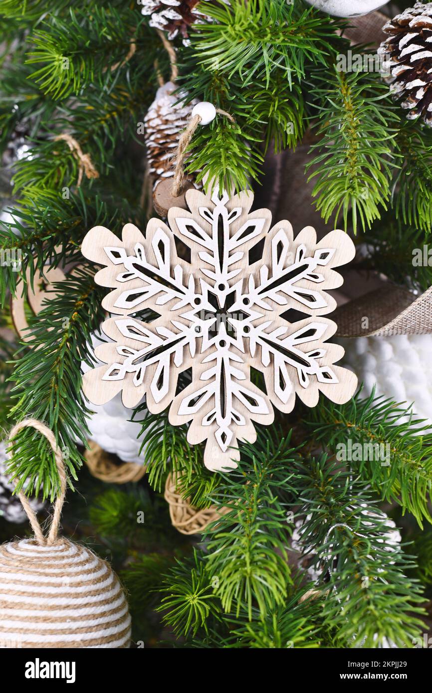 Christmas tree branch with natural wooden snowflake ornament Stock Photo