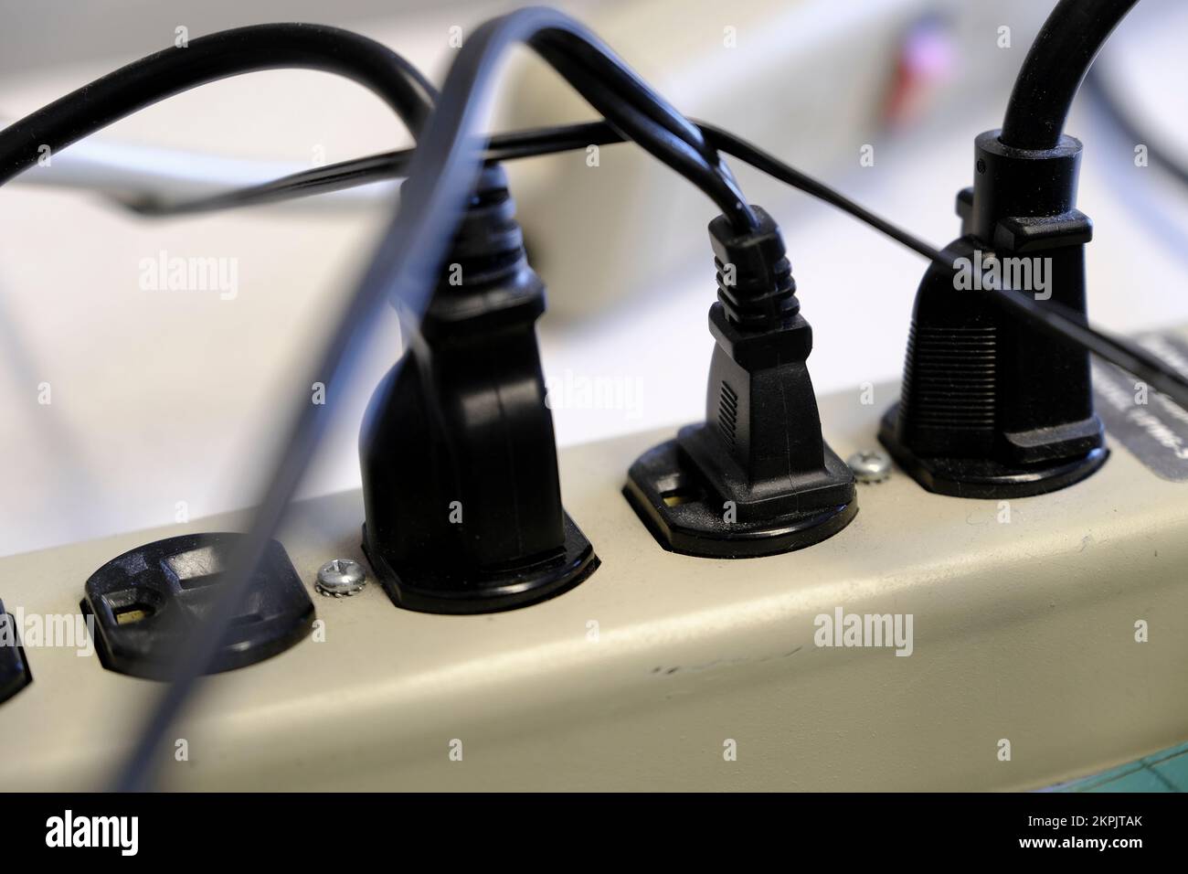 Many power plugs plugged in and cords jumbled and Stock