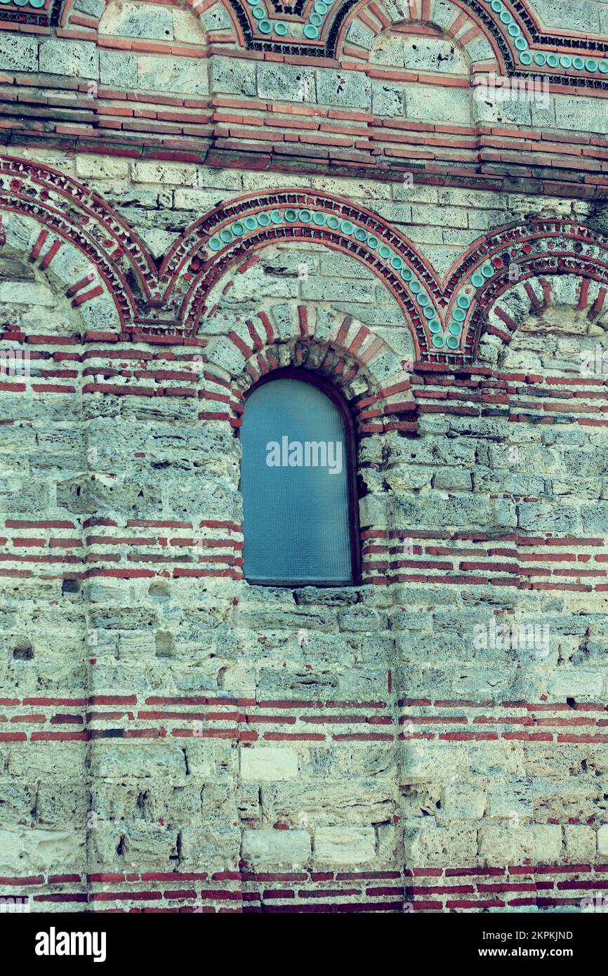 Facade of an old high wall with a window in fortress. Wall is made of ...