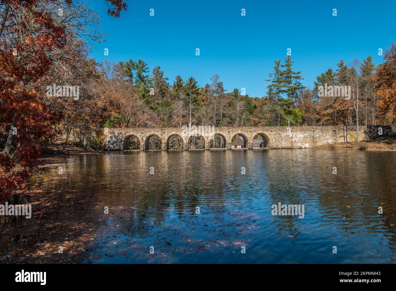 A picturesque view in autumn of the seven arch stone bridge that crosses over a lake at the state park in Tennessee on a sunny day Stock Photo