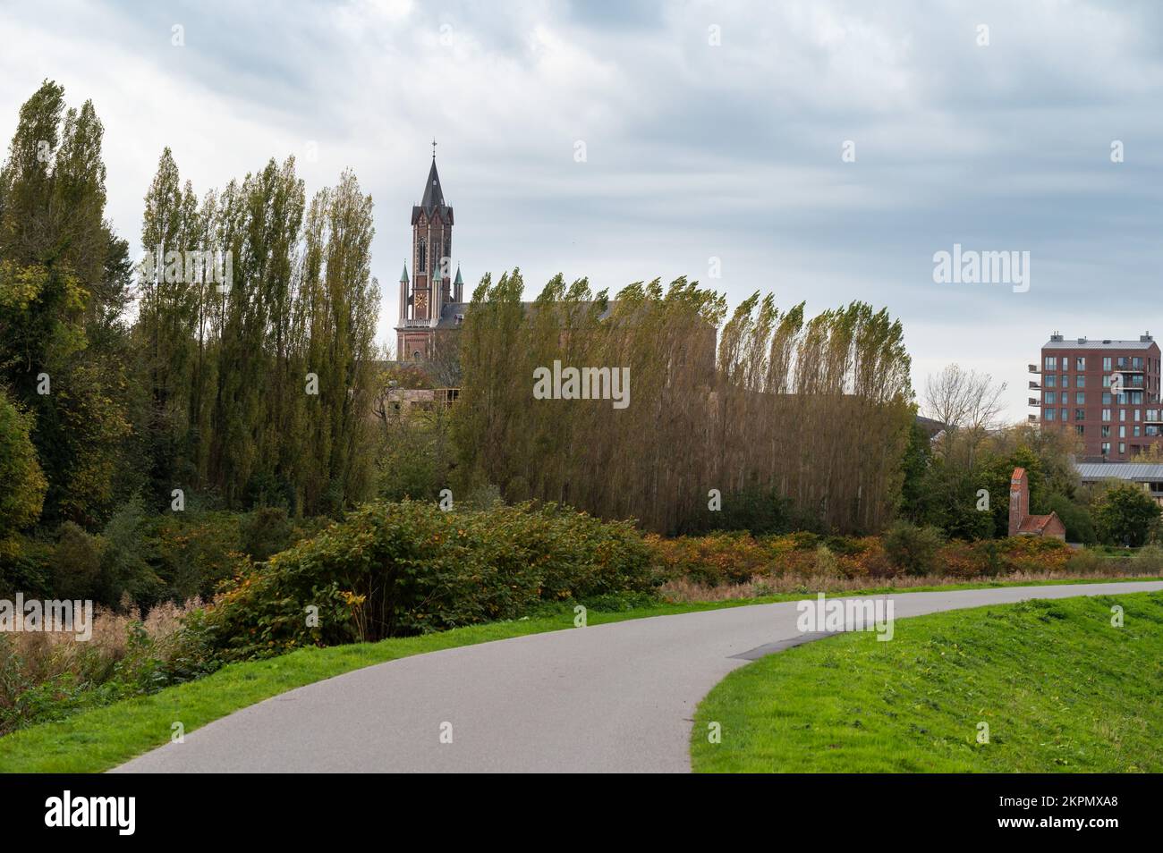 Wetteren, East Flemish Region, Belgium, 11 03 2022 - View over a bending cycling trail and the church tower Stock Photo