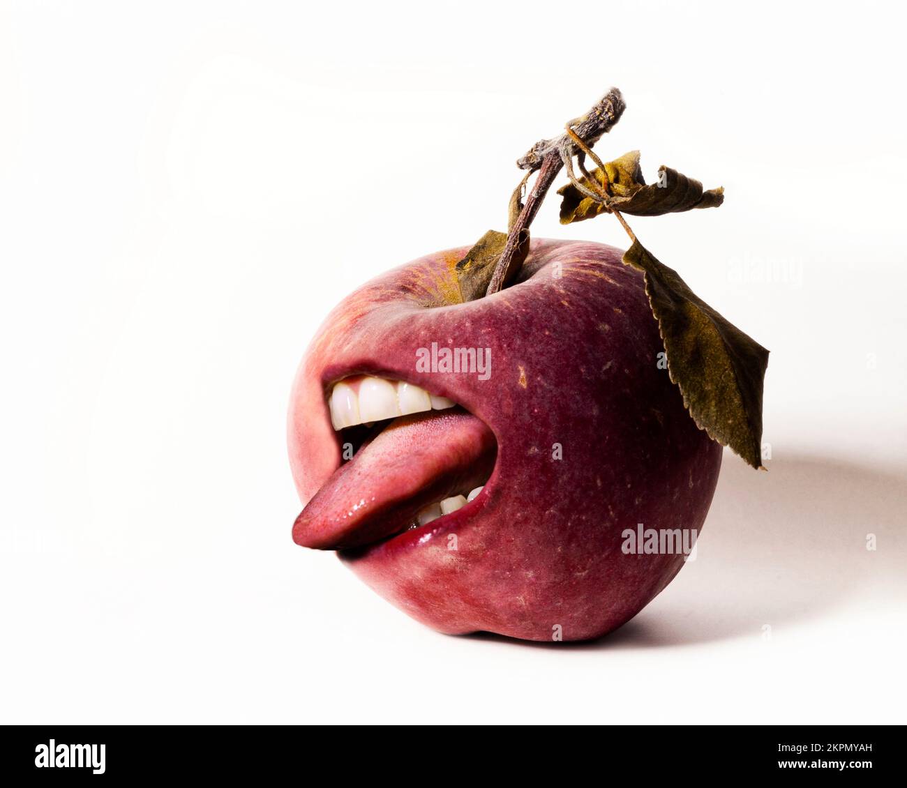 A simple surrealist photograph of a red apple with a mouth and tongue