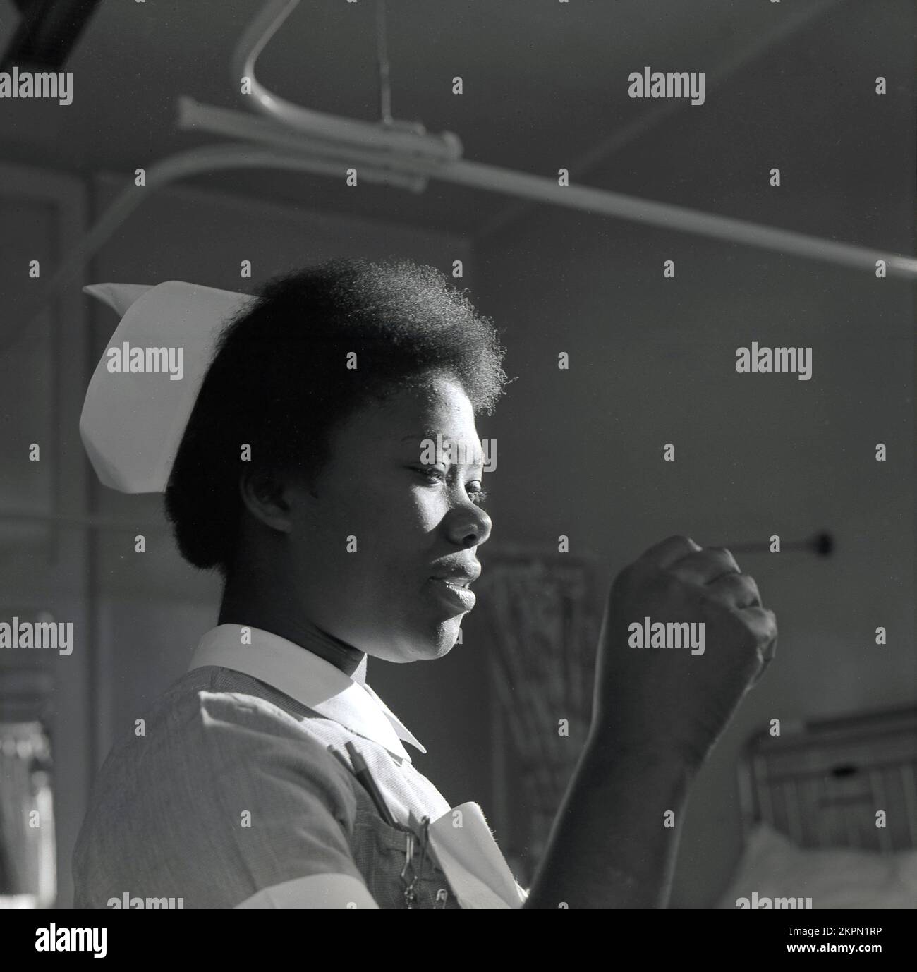 1969, historical, side profile,  on a hospital ward, a young female NHS nurse of Caribbean descent, Warwick Hospital, England, UK. Stock Photo