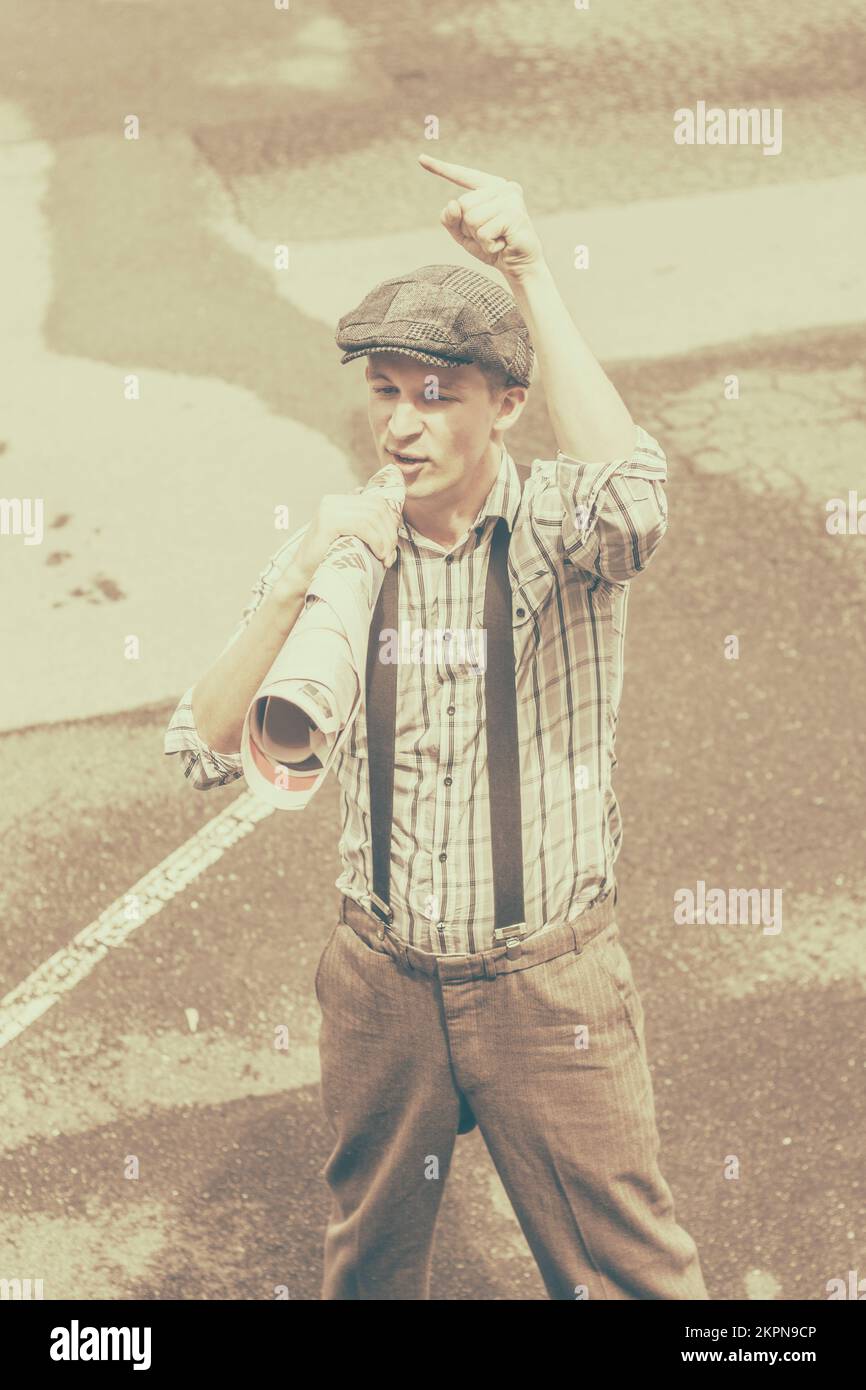 Old toned picture of a newsboy selling the news through a rolled up