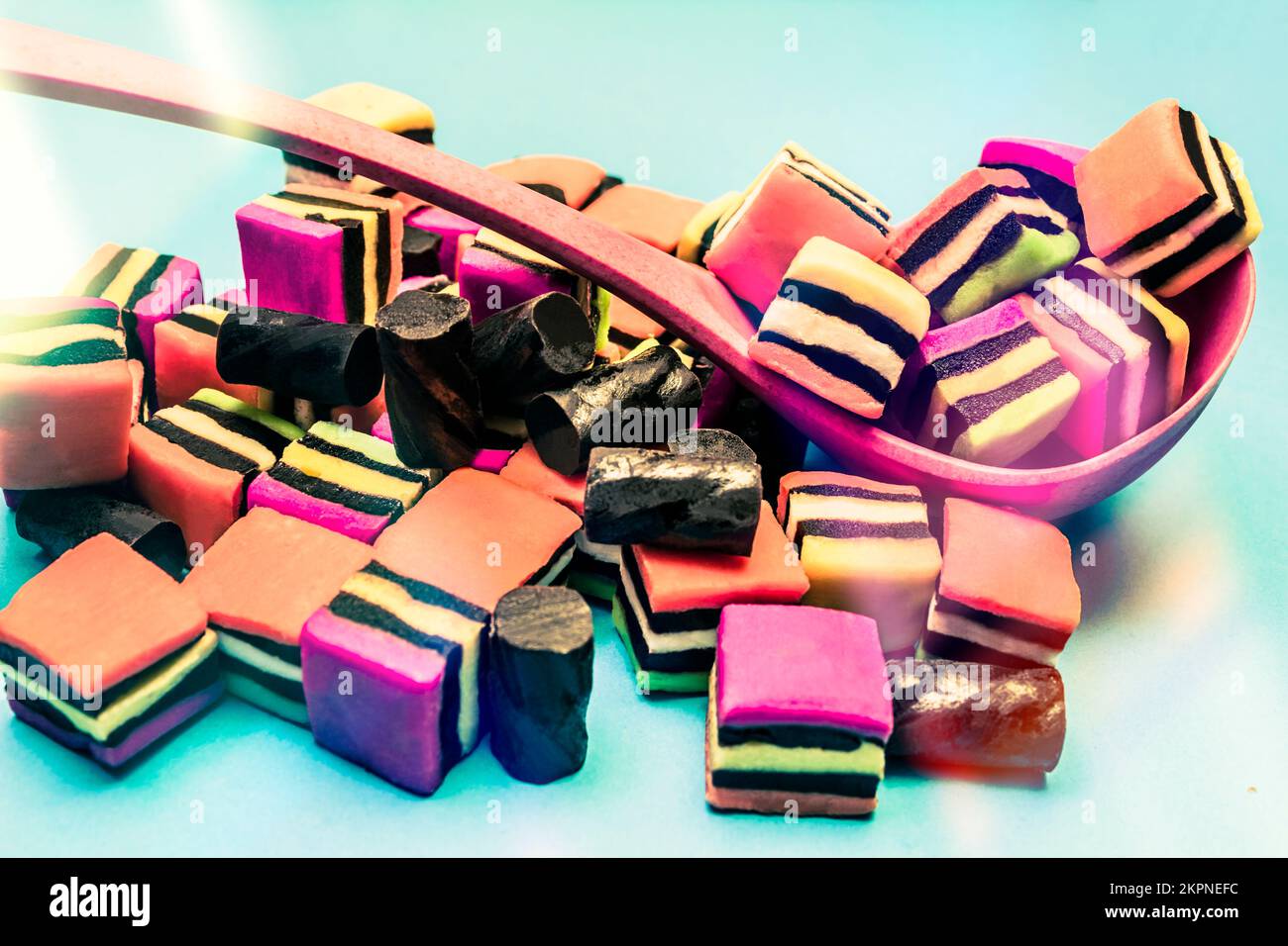 Pile of black liquorice allsorts and square colorful lolly chunks