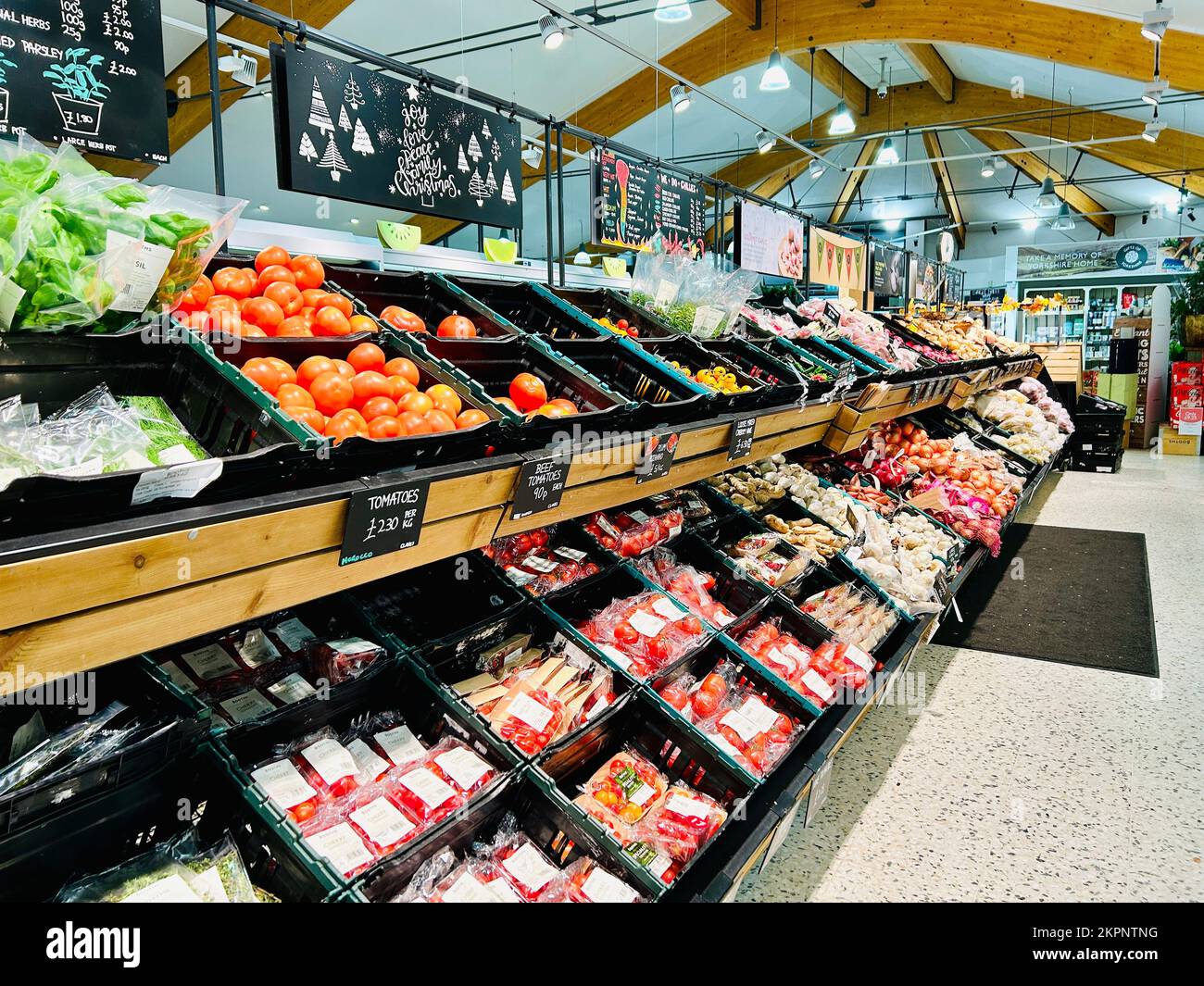 Tomatoes and fresh vegetables on the fresh produce aisle of a Booths