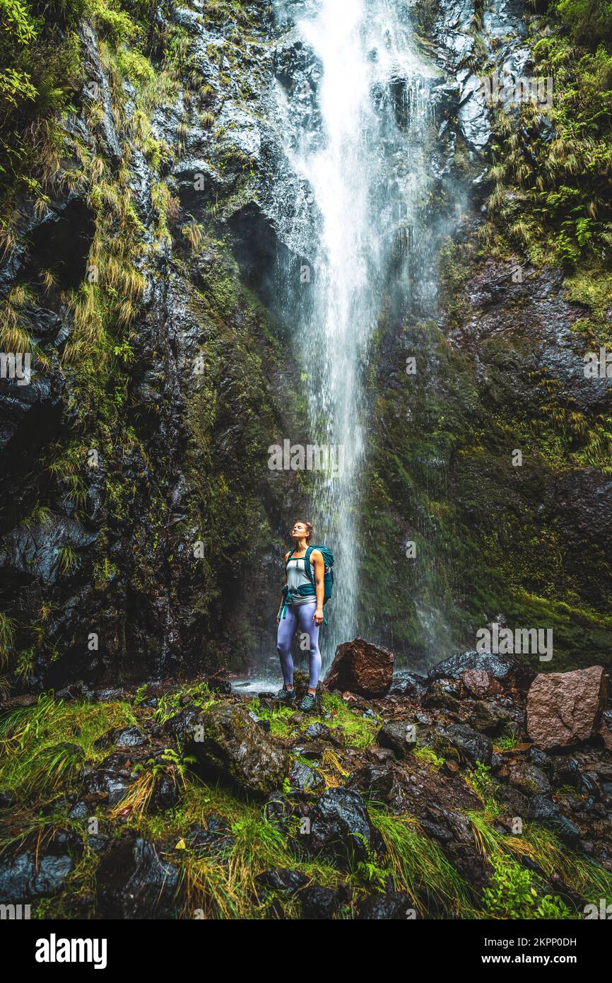 Description: Sportive woman enjoys fresh air water fall atmosphere. Levada of Caldeirão Verde, Madeira Island, Portugal, Europe. Stock Photo