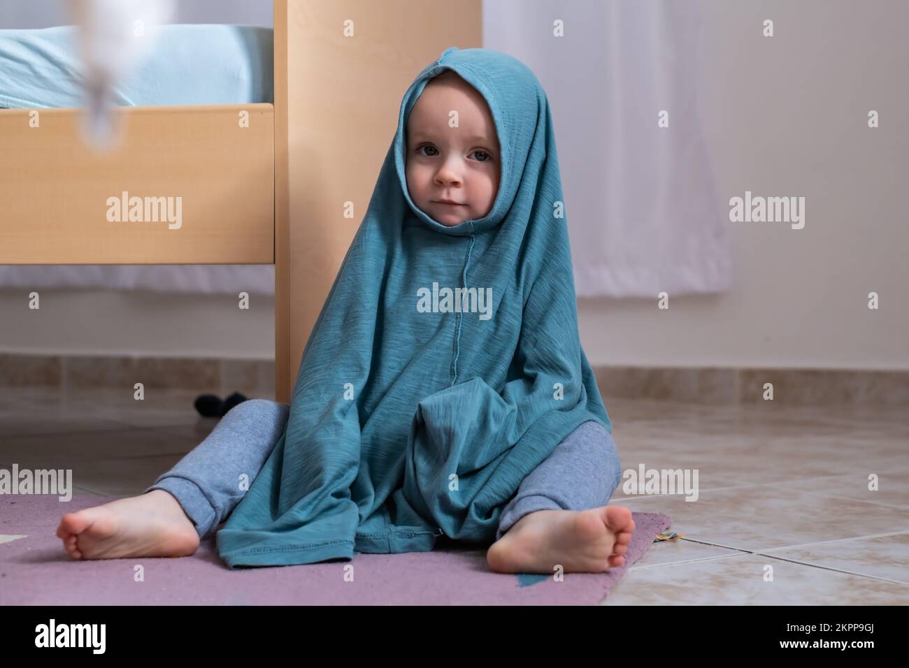 Cute baby girl dressing herself at her mother tshirt Stock Photo Alamy
