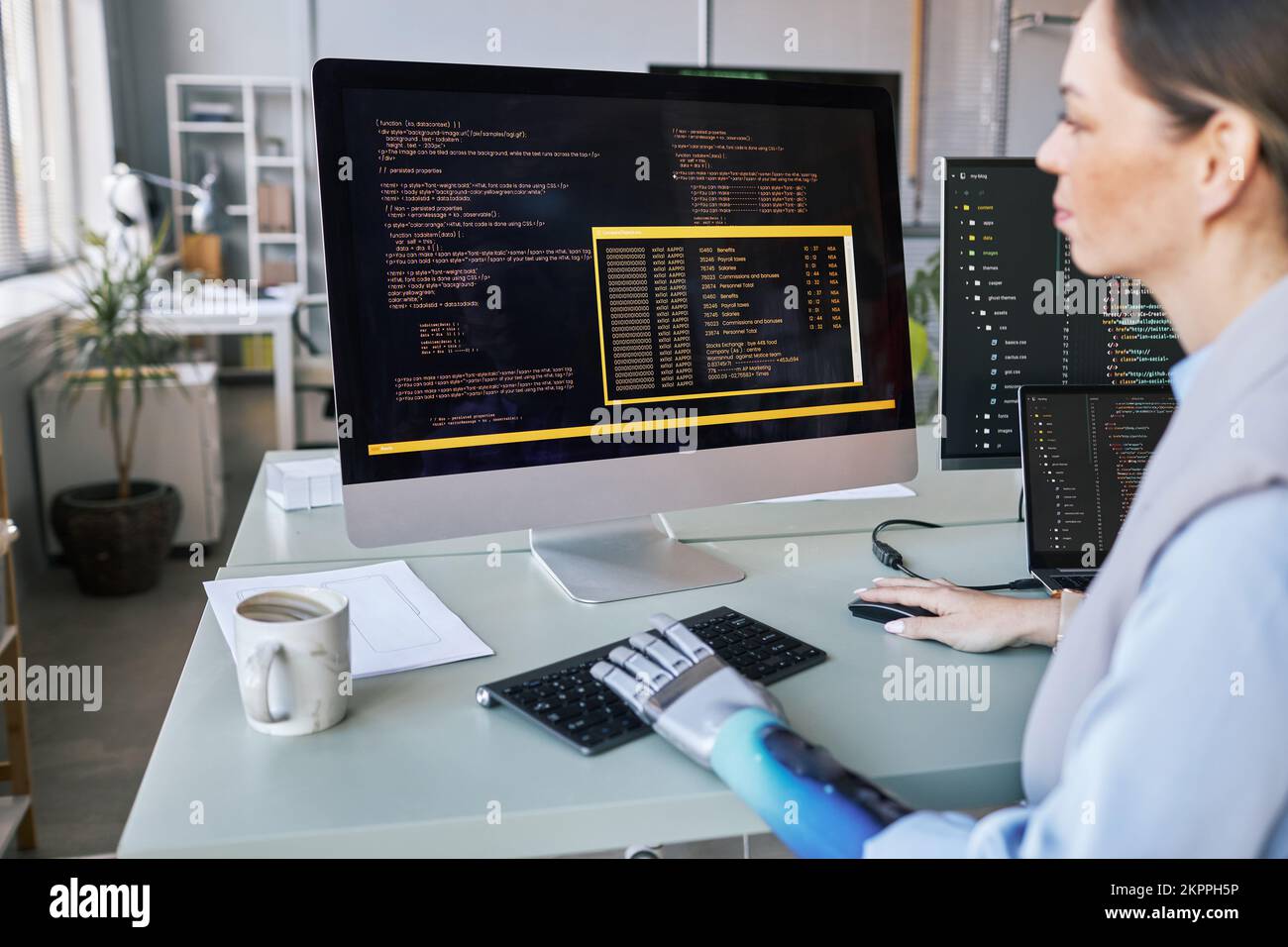 Software developer with prosthetic arm checking programming code on ...