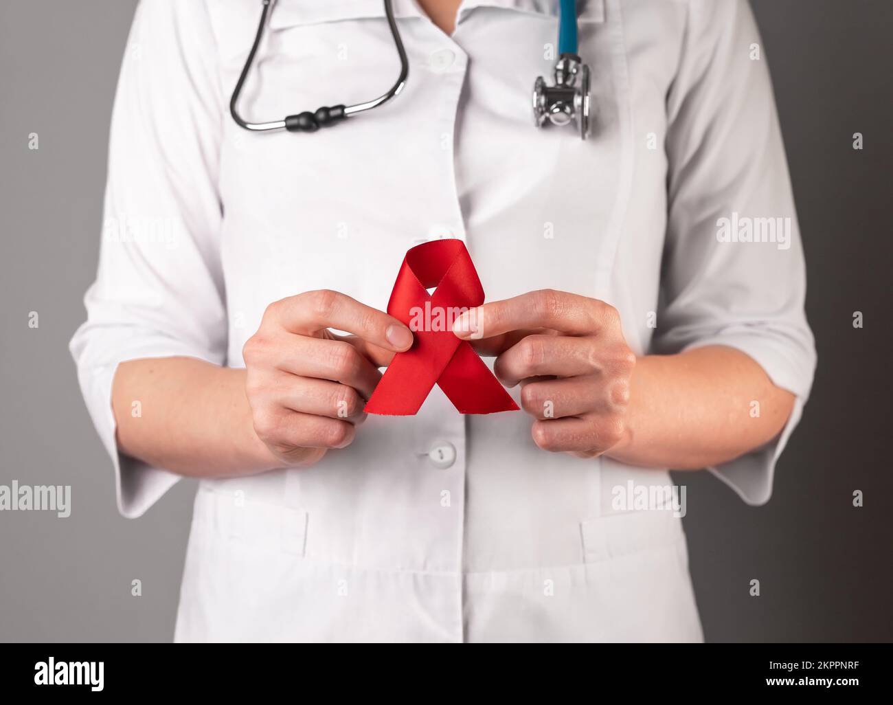 Red ribbon in doctors hand, symbol of HIV and AIDS awareness day, 1 ...