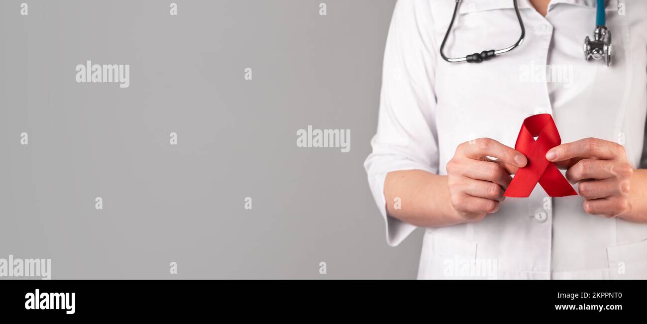 Red ribbon in doctors hand, symbol of HIV and AIDS awareness day, 1 ...