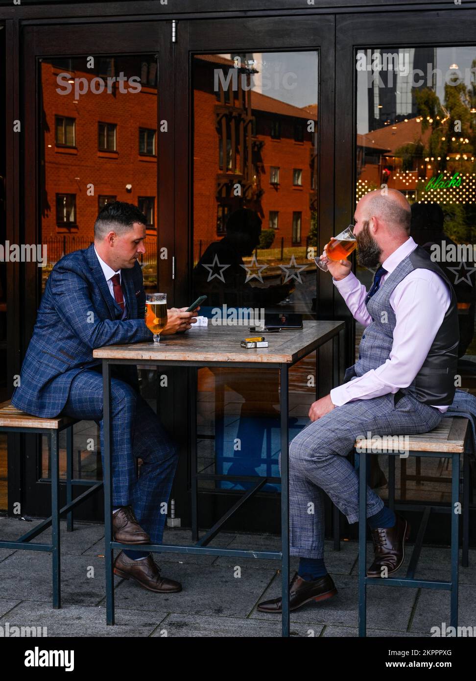 Two men in business suits enjoying a drink in Birmingham UK beside the canal Stock Photo
