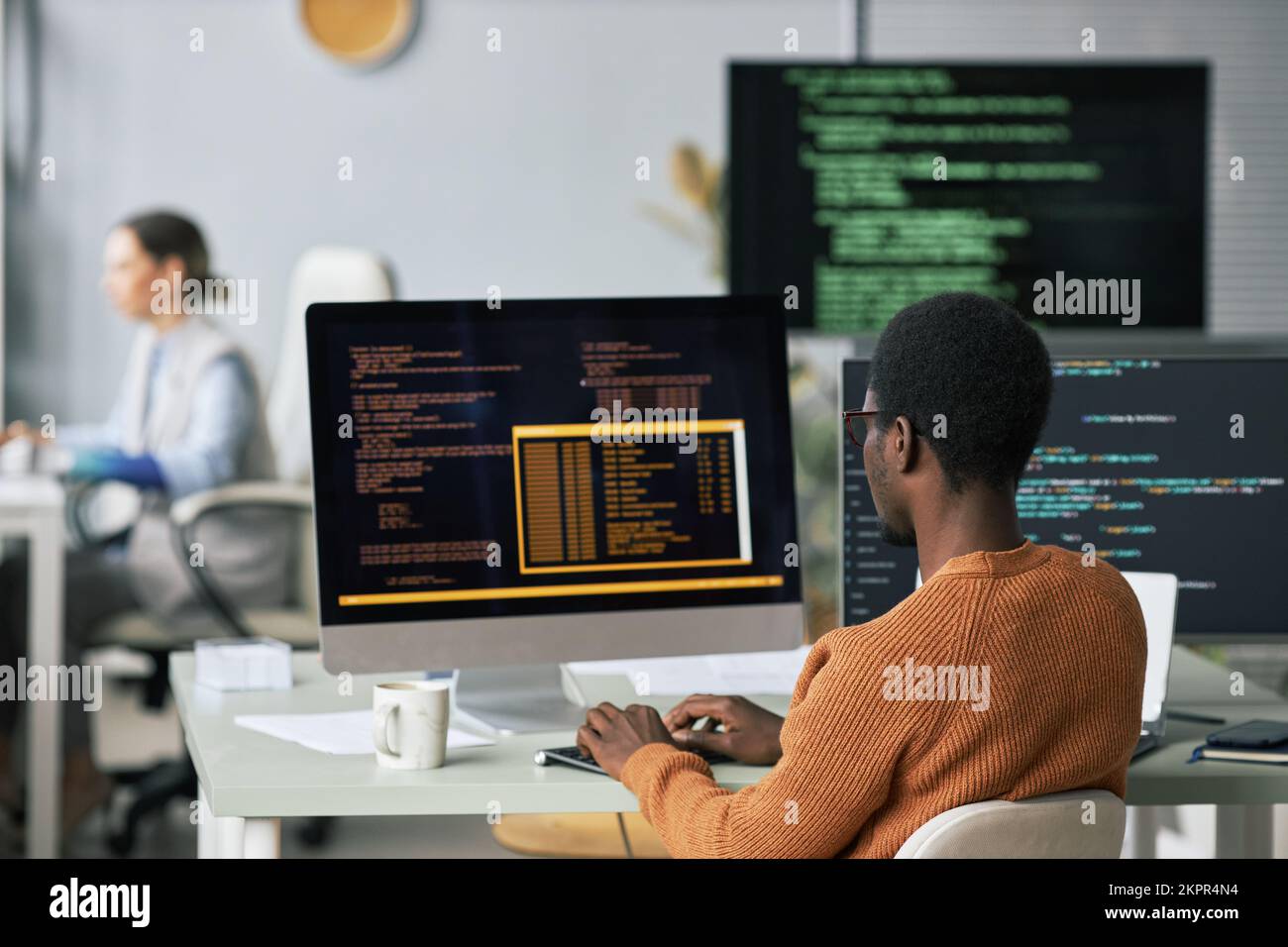Young Black man testing programming code he wrote for new application ...