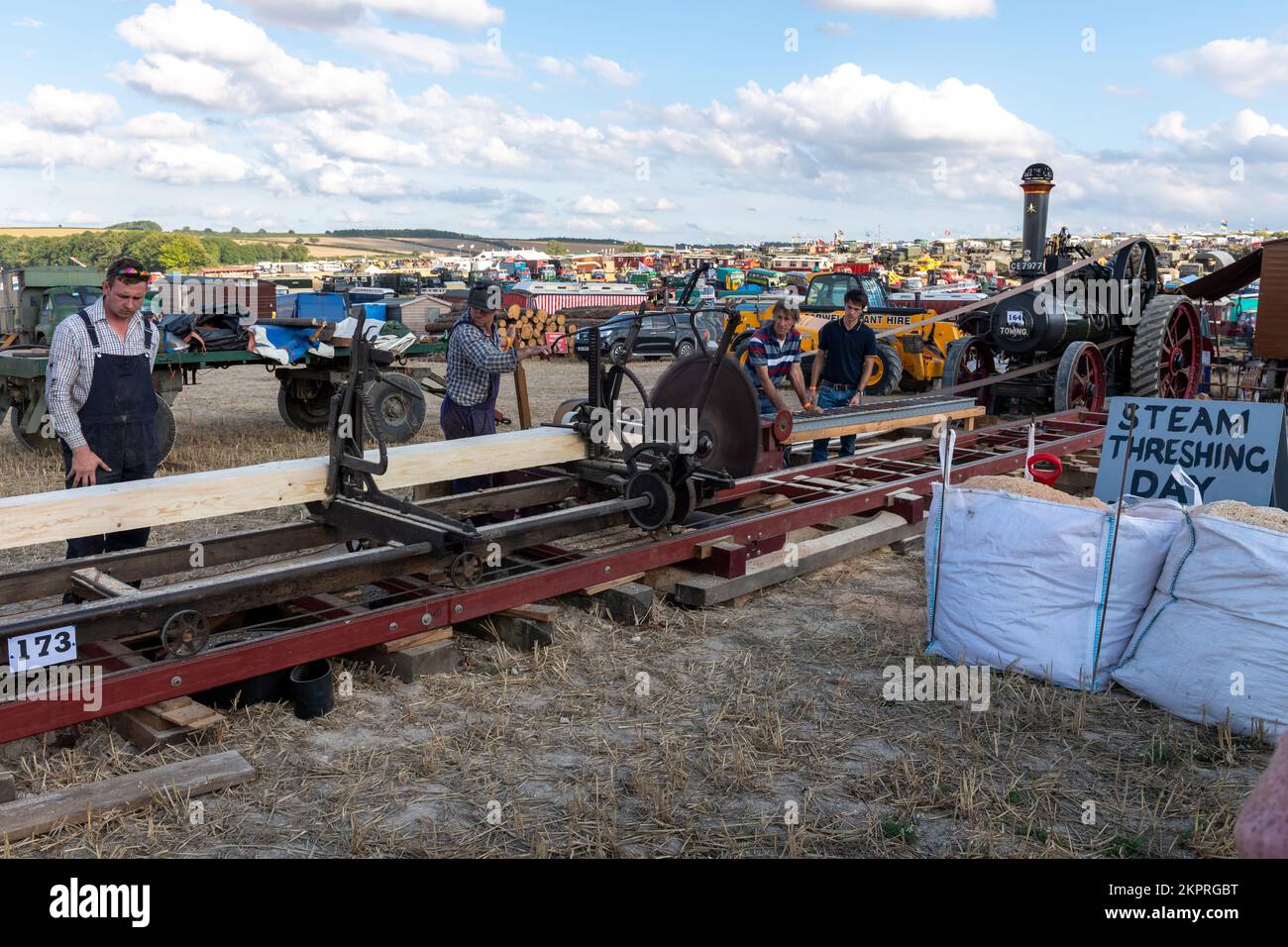 Tarrant Hinton.Dorset.United Kingdom.August 25th 2022.Enthusiasts are cutting timber using an old fashioned saw bench that is being driven by a tracti Stock Photo