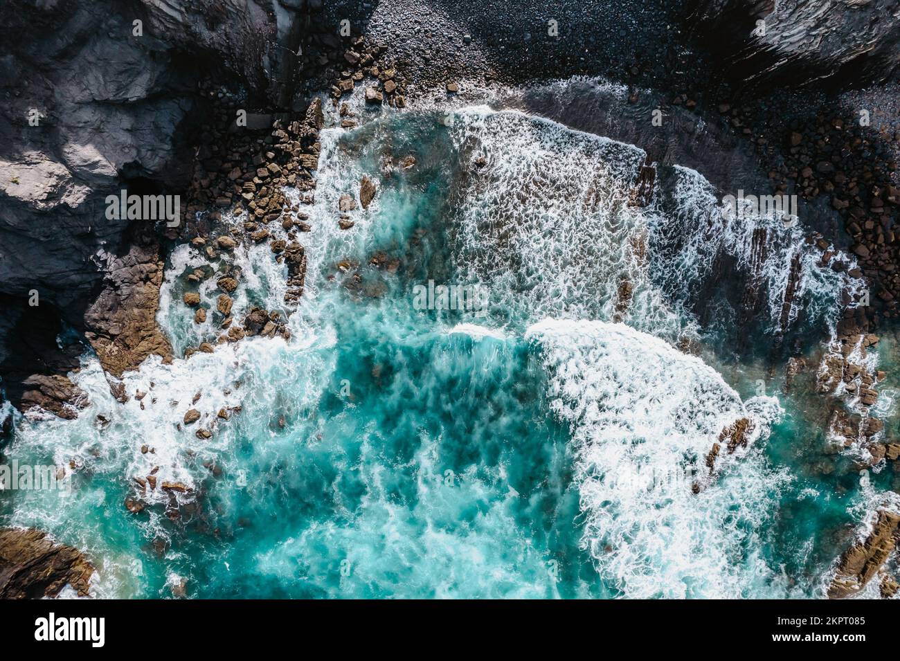 Wild high waves of Atlantic Ocean,turquise water,sandy beach in Portugal.Summer vacation travel concept.Top down view.Aerial view of wave breaking Stock Photo