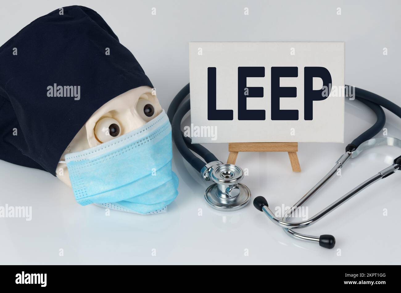 Medicine and health concept. On the table lies a skull in a mask and a cap, a stethoscope and an easel with a canvas on which it is written - LEEP Stock Photo