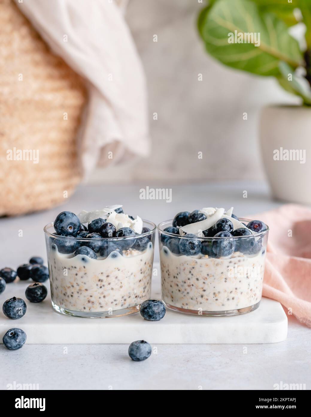Two cups of overnight oats and chia seeds with fresh blueberries and