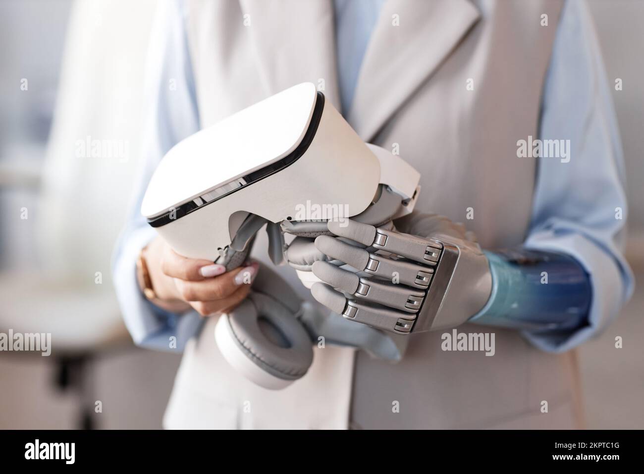 VR headset in prosthetic hand of female scientist Stock Photo