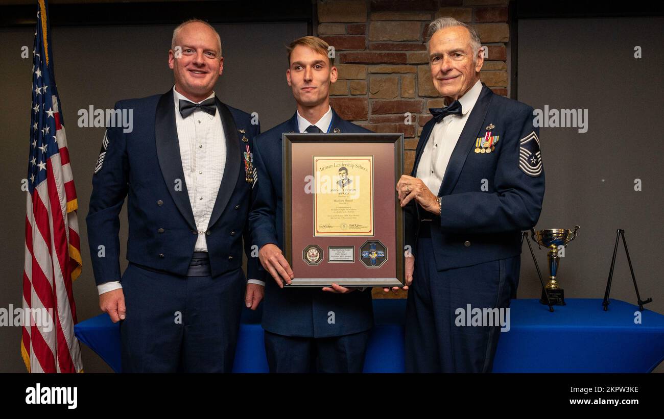 U.S. Air Force Staff Sgt. Matthew Hensel, center, accepts the John L. Levitow Award from U.S. Air Force Chief Master Sgt. Mark Teusch, 49th Component Maintenance Squadron senior enlisted leader, left, and retired U.S. Air Force Chief Master Sgt. Richard McElderry during an Airman Leadership School graduation at Holloman Air Force Base, New Mexico, Nov. 3, 2022. The Levitow award is presented to the student demonstrating the highest level of leadership and scholastic performance. Stock Photo