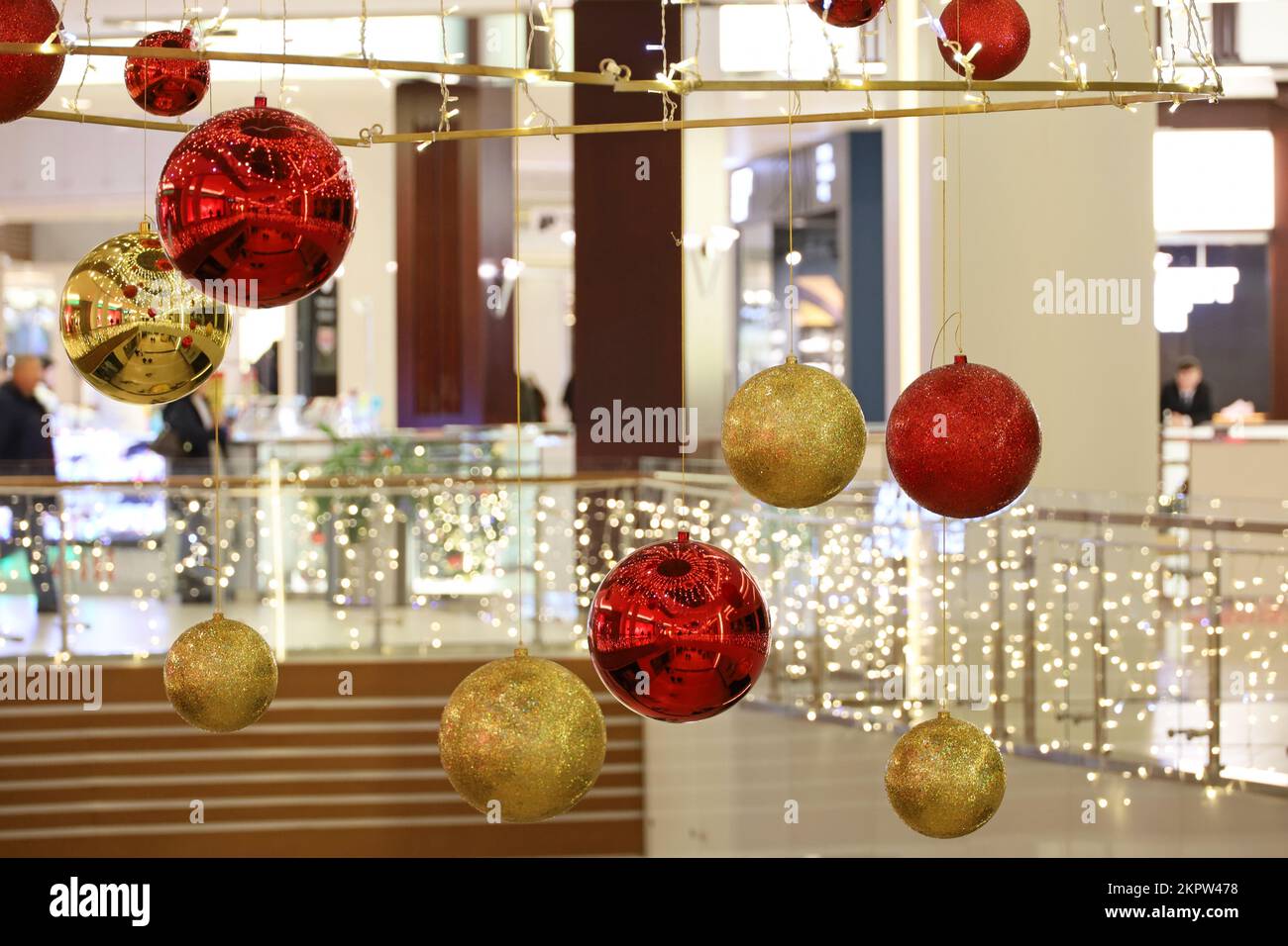 New Year decorations in a shopping mall. Red and golden toy balls hanging in a store during Christmas holidays Stock Photo
