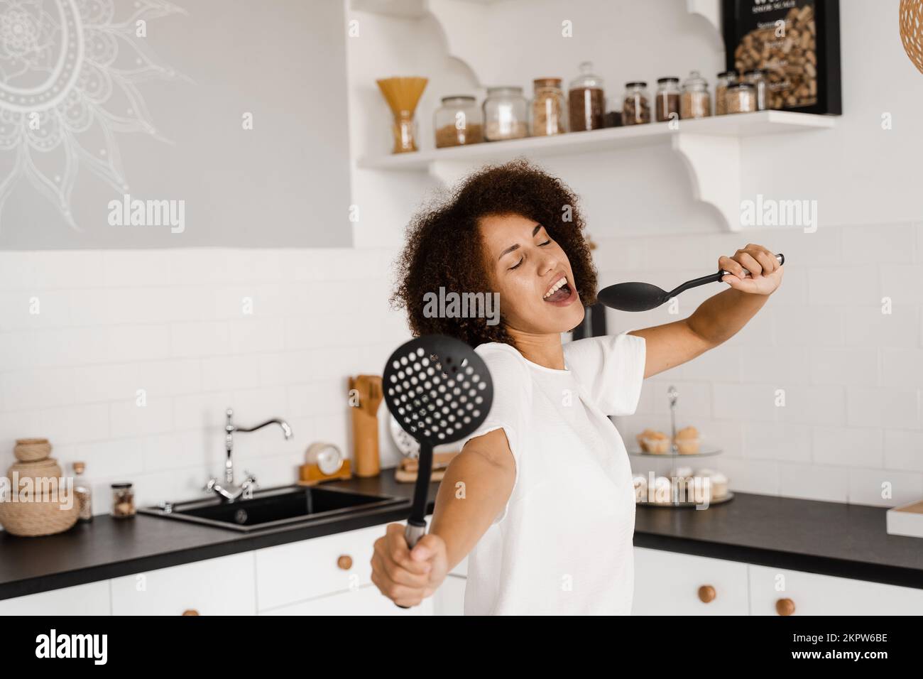 Funny young housewife cooking in kitchen Stock Photo - Alamy