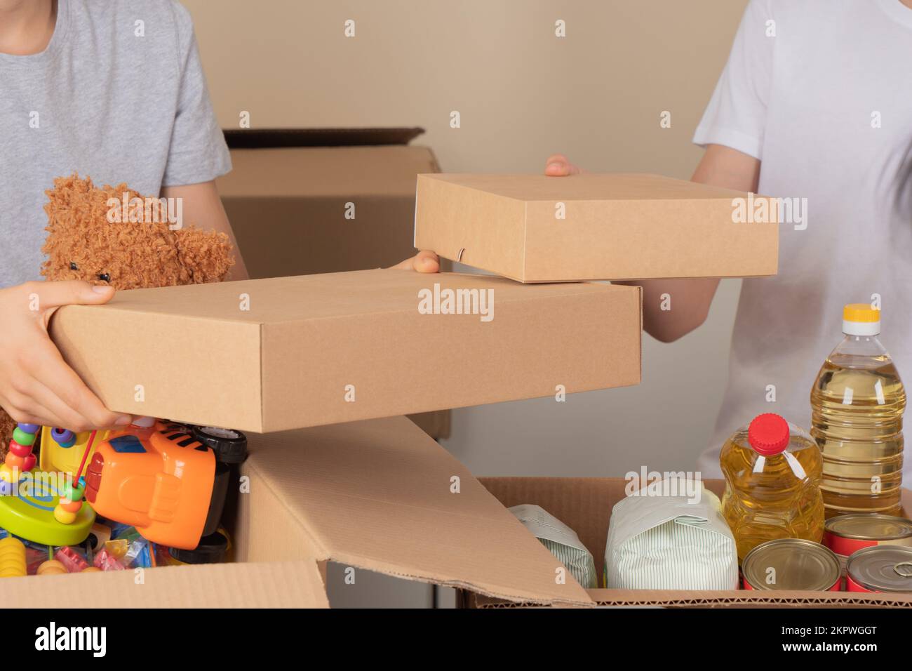 Young volunteers collect donations for charity indoors. Donation boxes