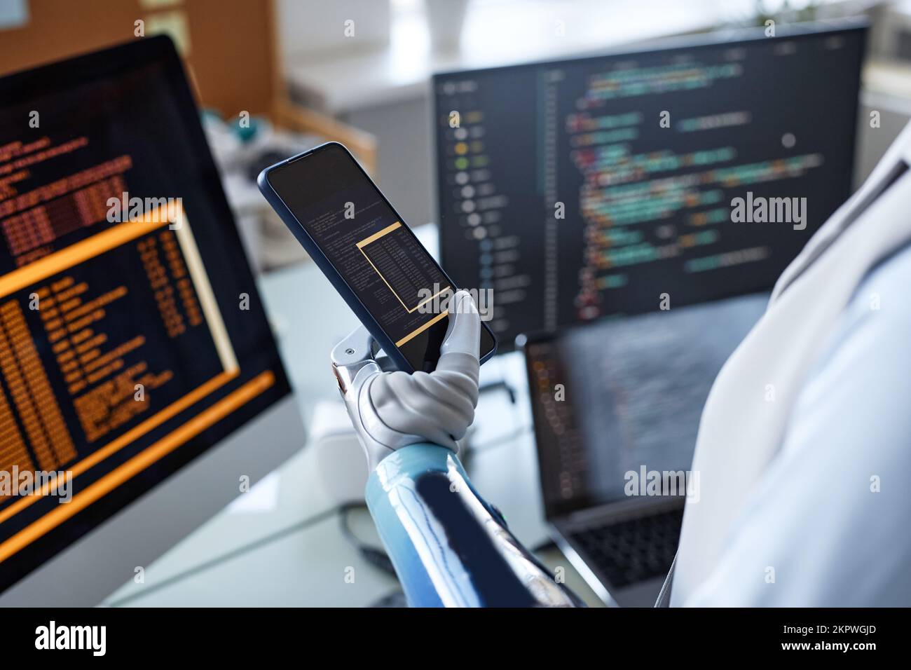 Closeup image of software developer with prosthetic arm testing code on smartphone Stock Photo