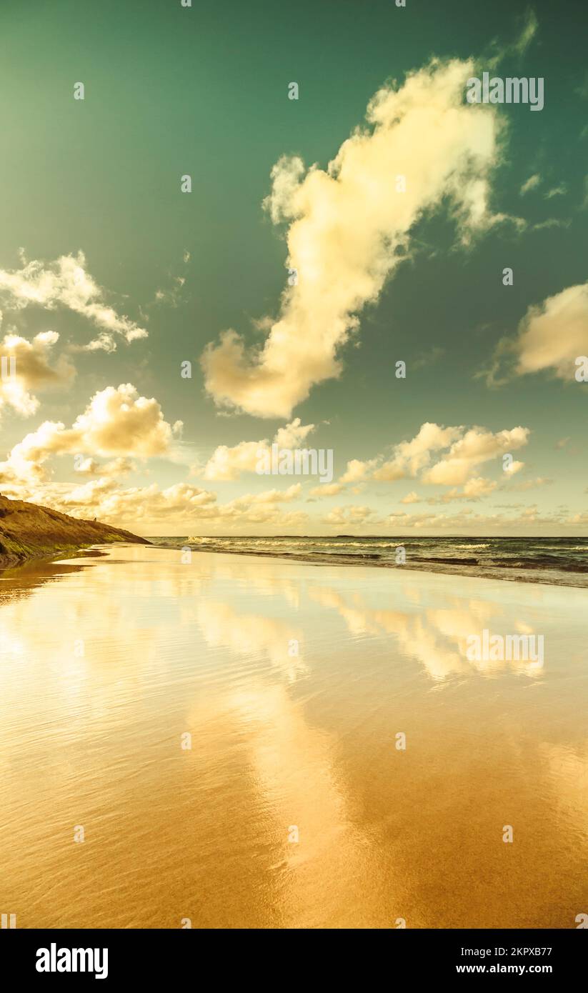 Placid landscape photo on smooth beach scene of low tides and clouded skies reflected. Deadman's Beach, North Stradbroke Island, Queensland, Australia Stock Photo