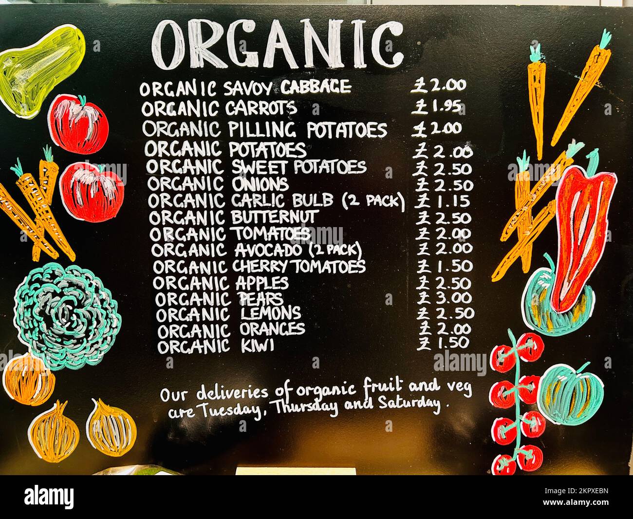 Organic fruit and vegetables sign with prices on a blackboard in a