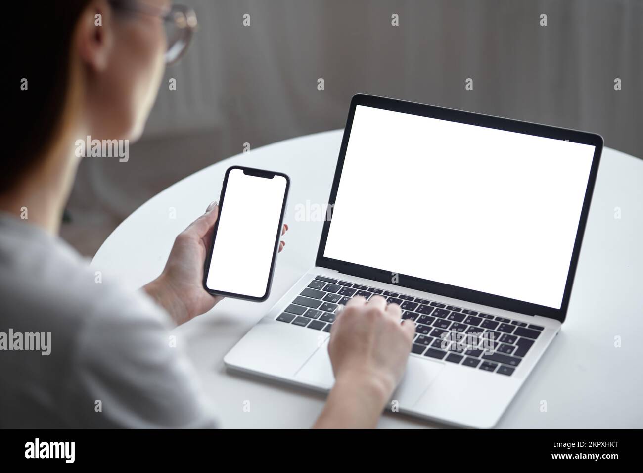 Mockup white screen laptop and mobile phone woman using computer while ...