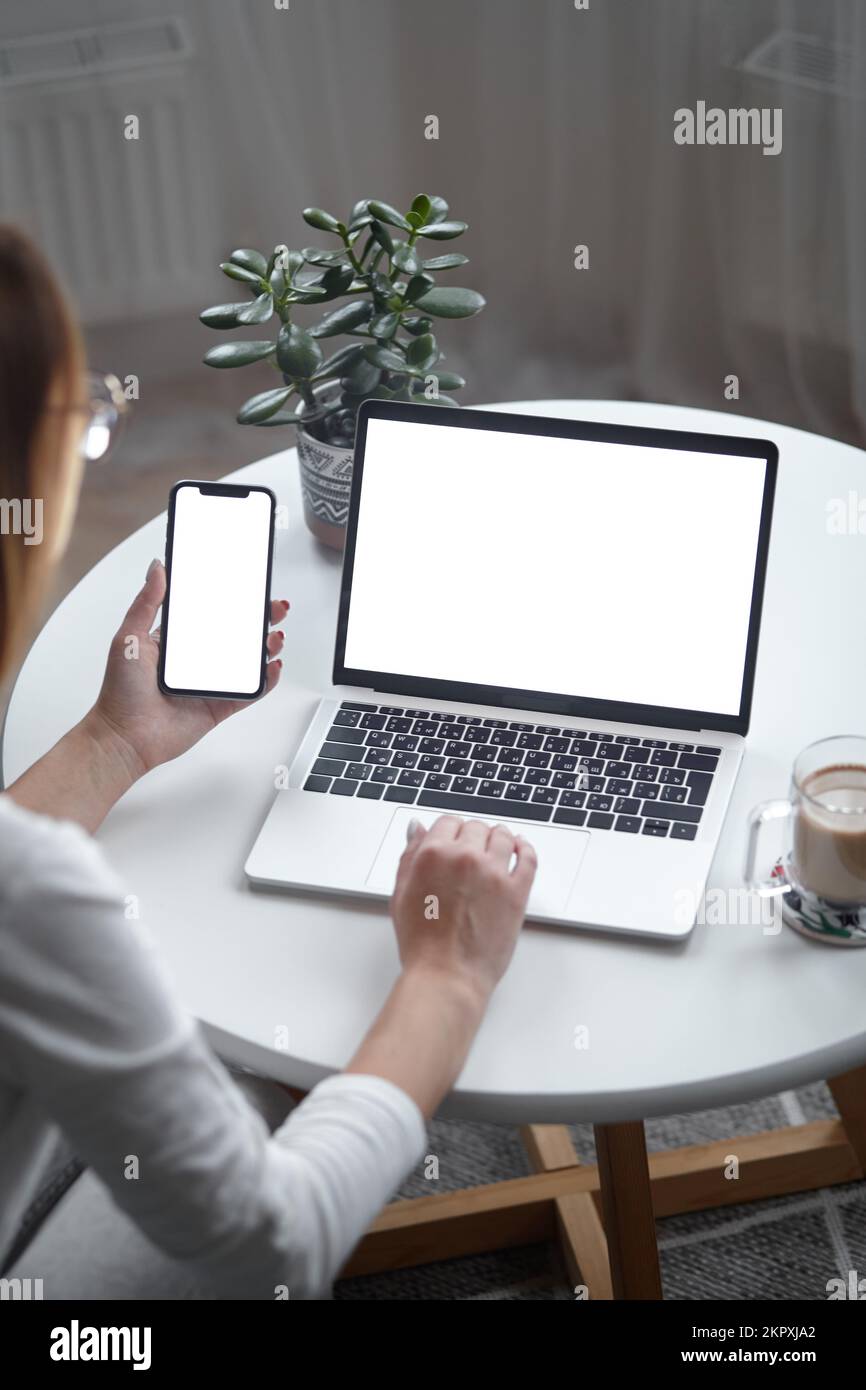 Mockup white screen laptop and mobile phone woman using computer while ...