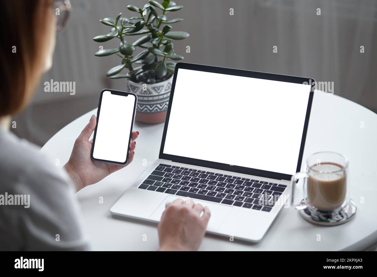 Mockup white screen laptop and mobile phone woman using computer while ...