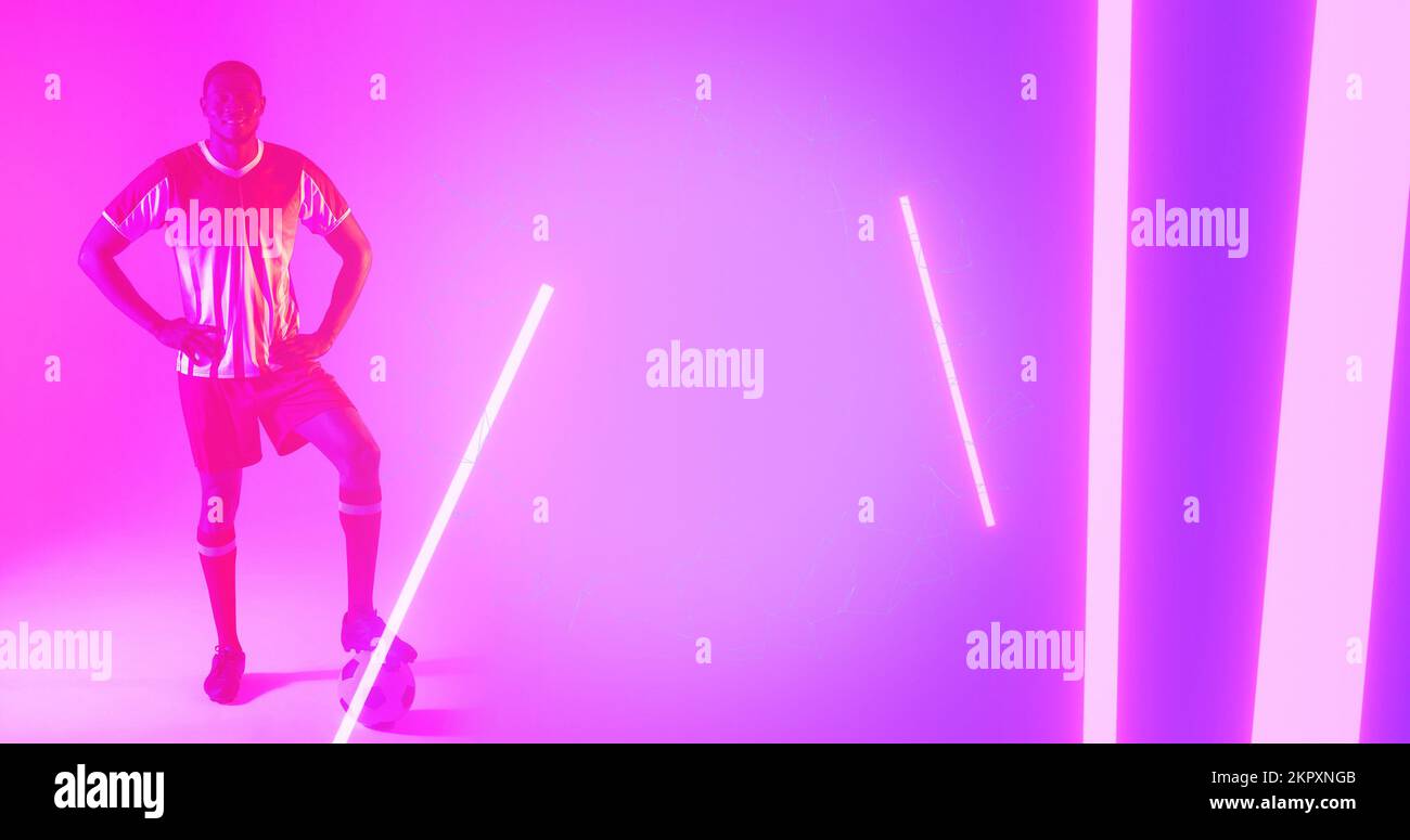 African american male player with leg on soccer ball and hands on hip