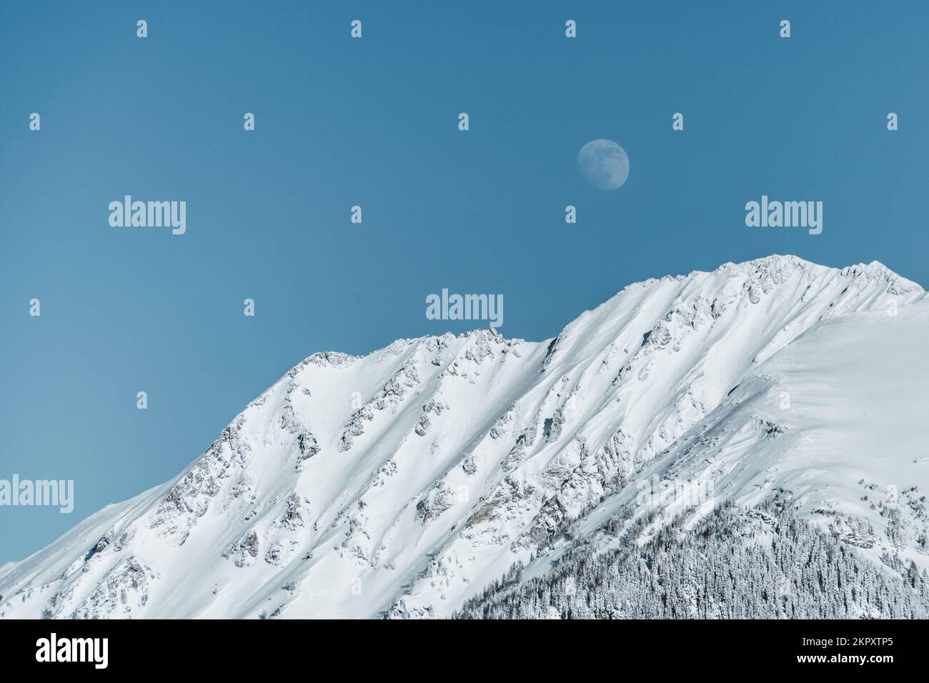 Moon rising above snow covered mountain range in the Austrian alps, Gastein, Salzburg, Austria Stock Photo