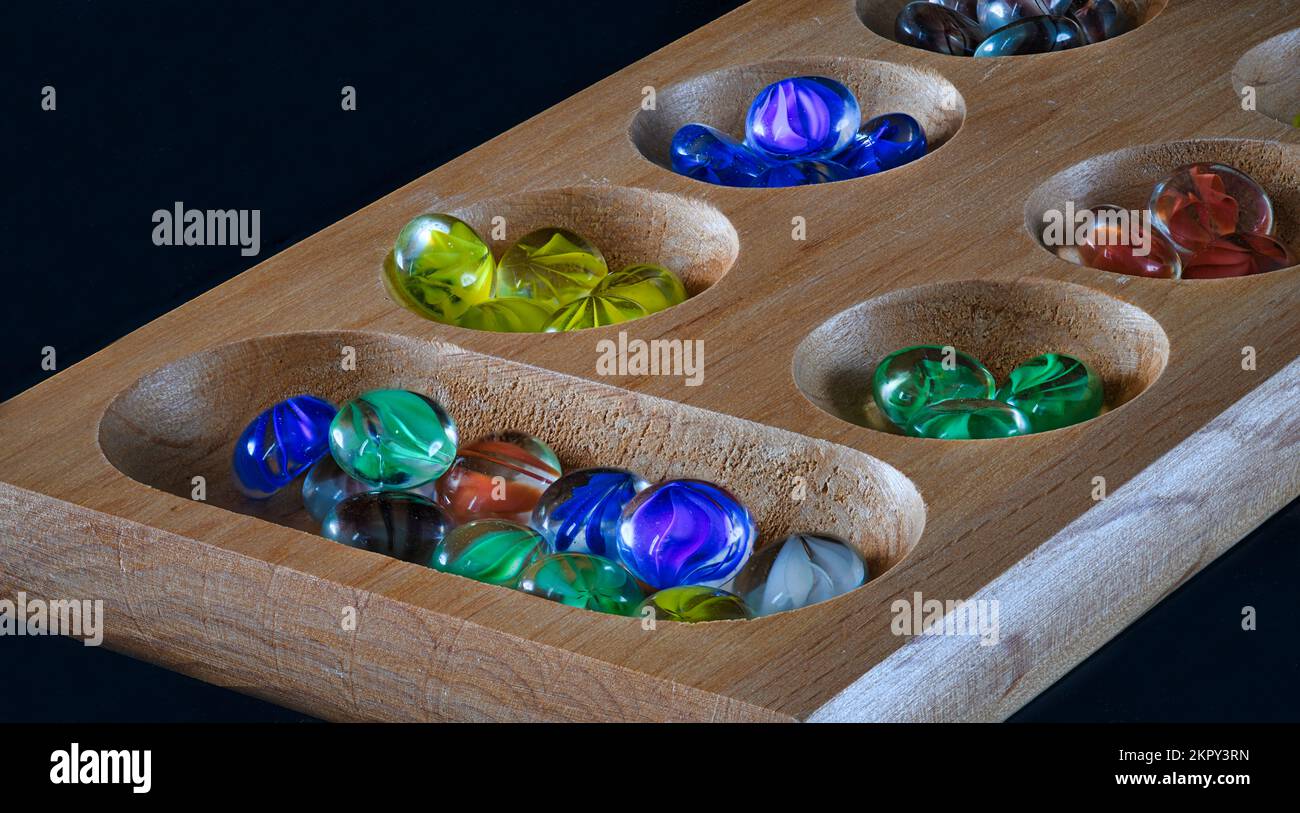 Wooden Board and Glass Marble Mencala Stock Photo
